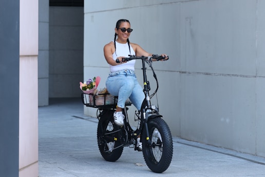 A woman rides an electric bike with flowers.