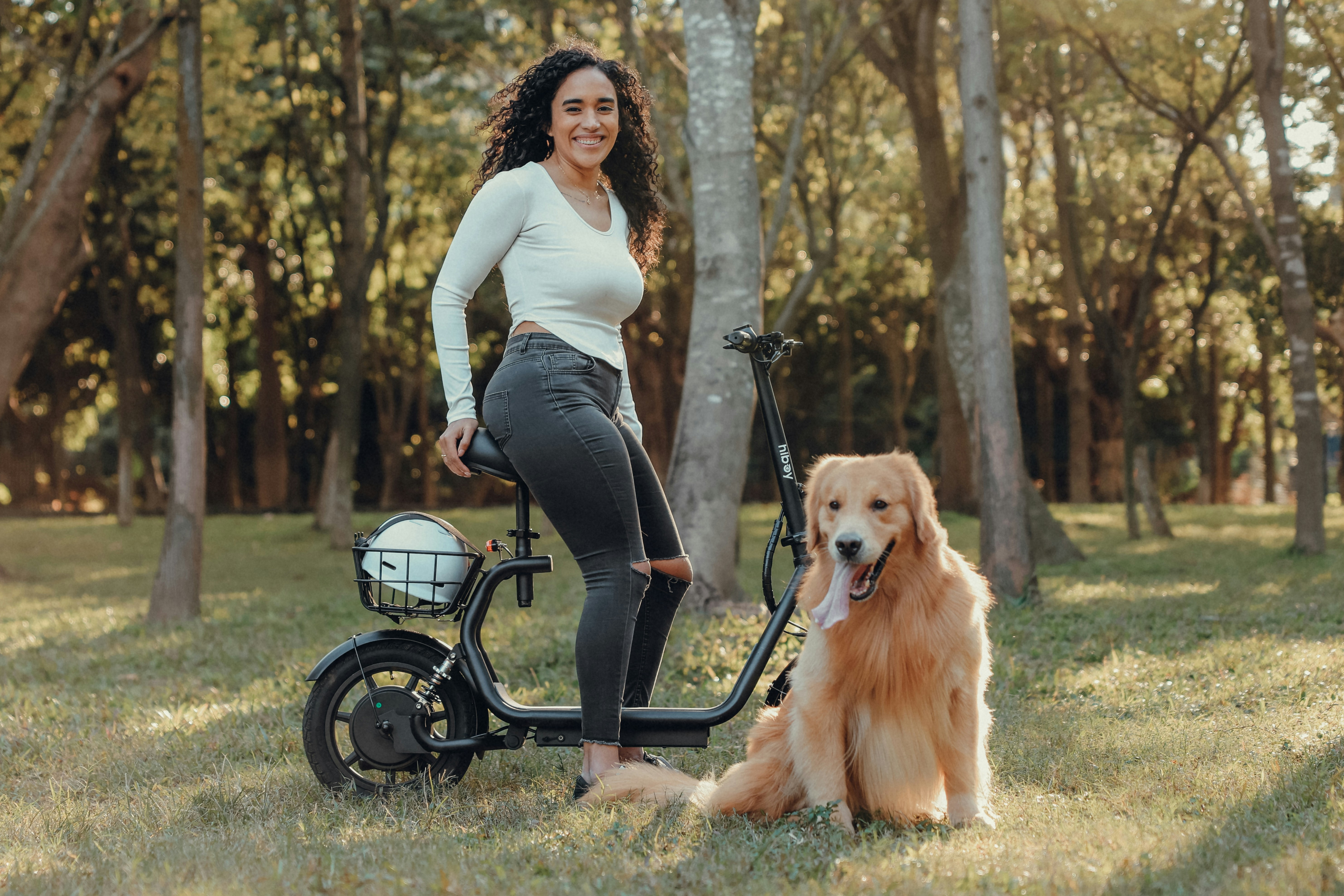 Mulher e seu golden retriever com uma scooter elétrica.