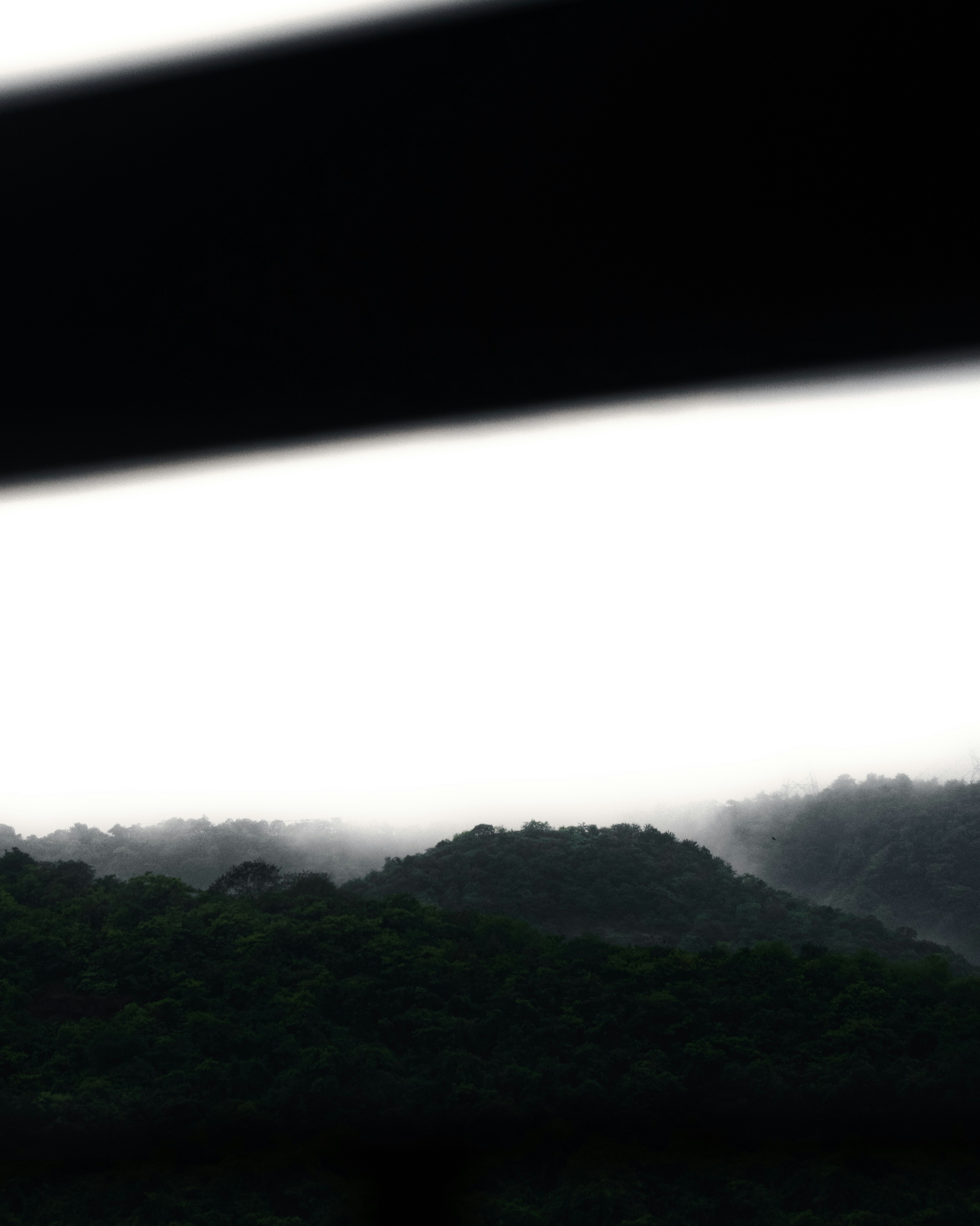 Overcast sky hovers above shadowy mountains.