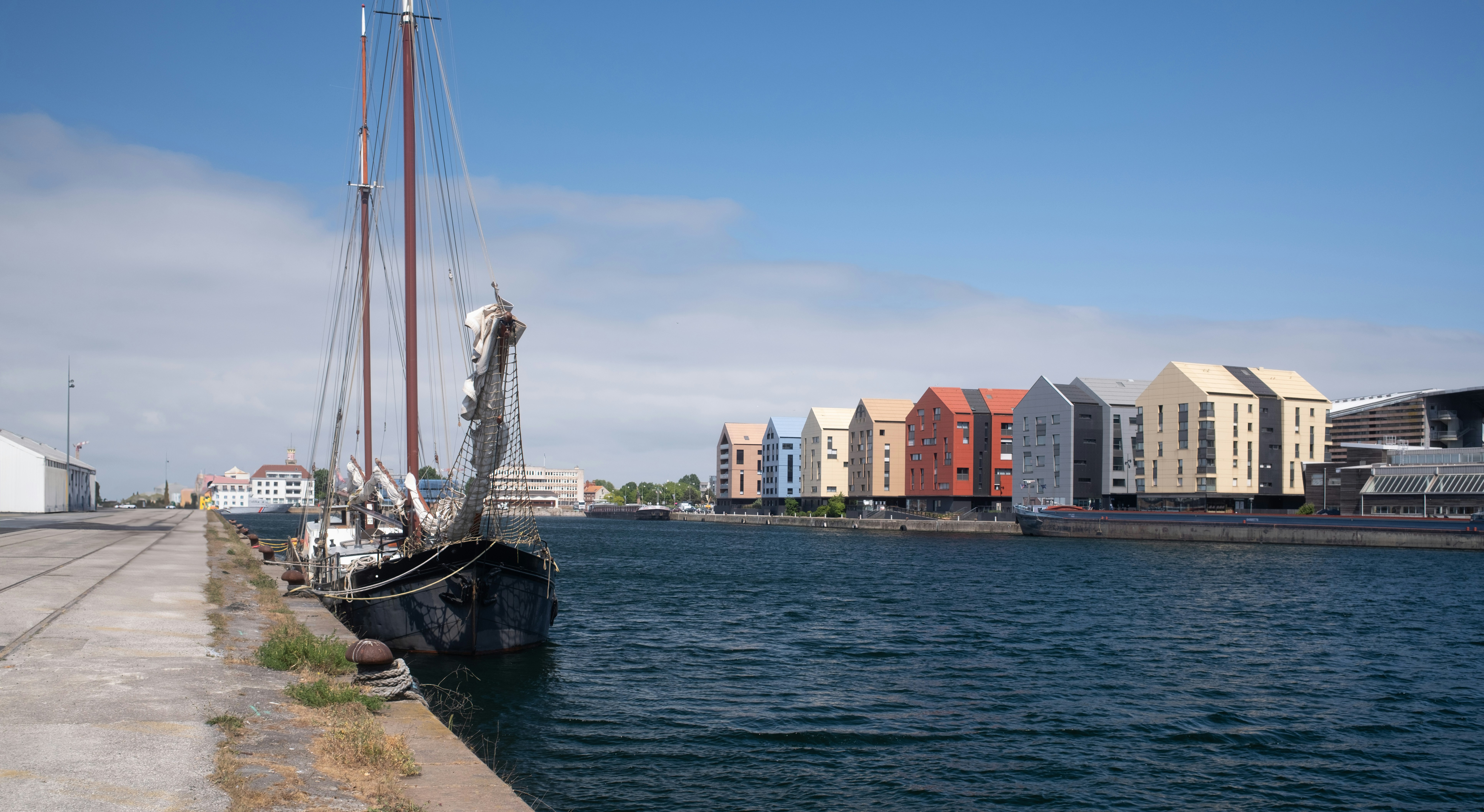 A sailboat and colorful houses line the canal.