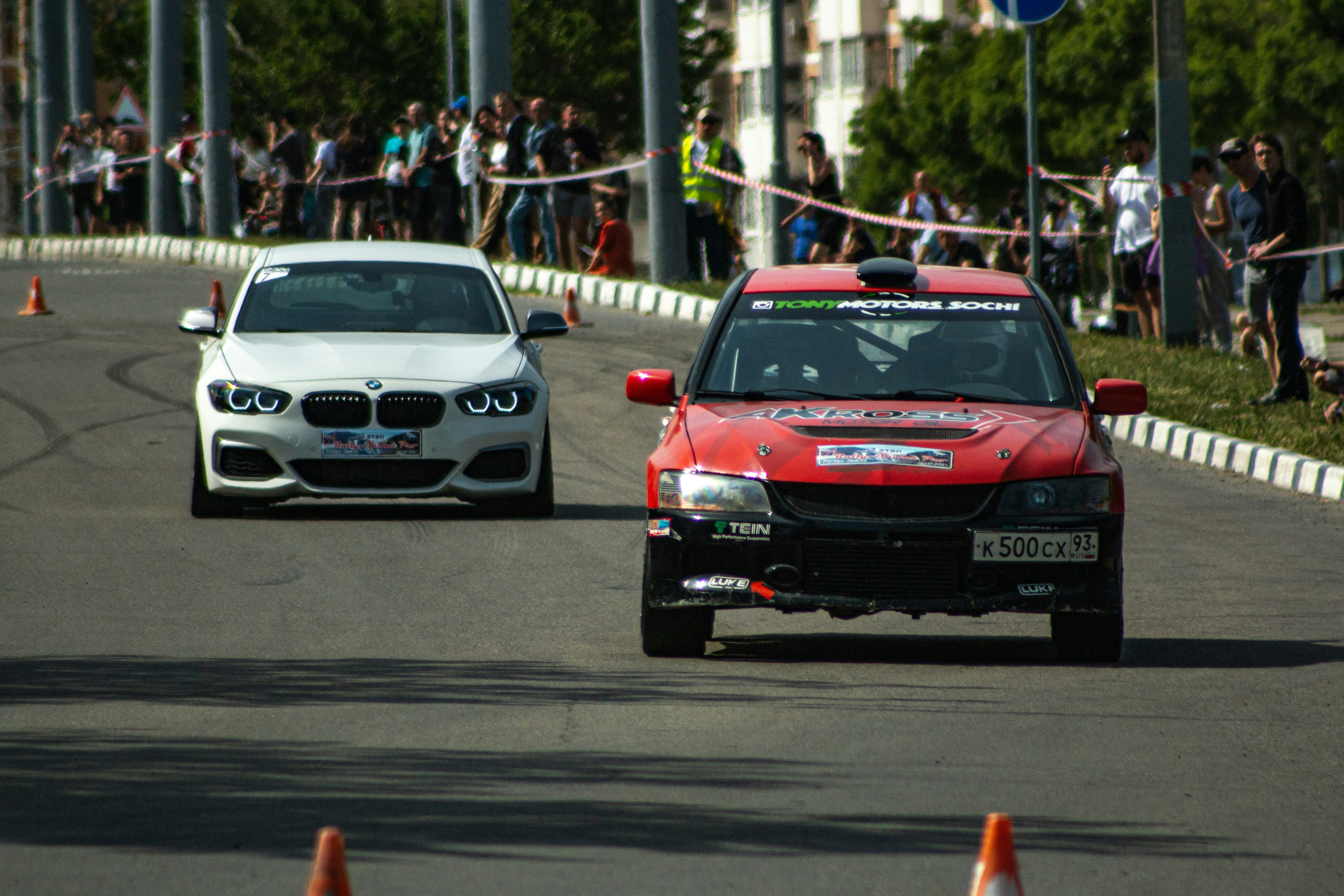 Two cars race down a street.