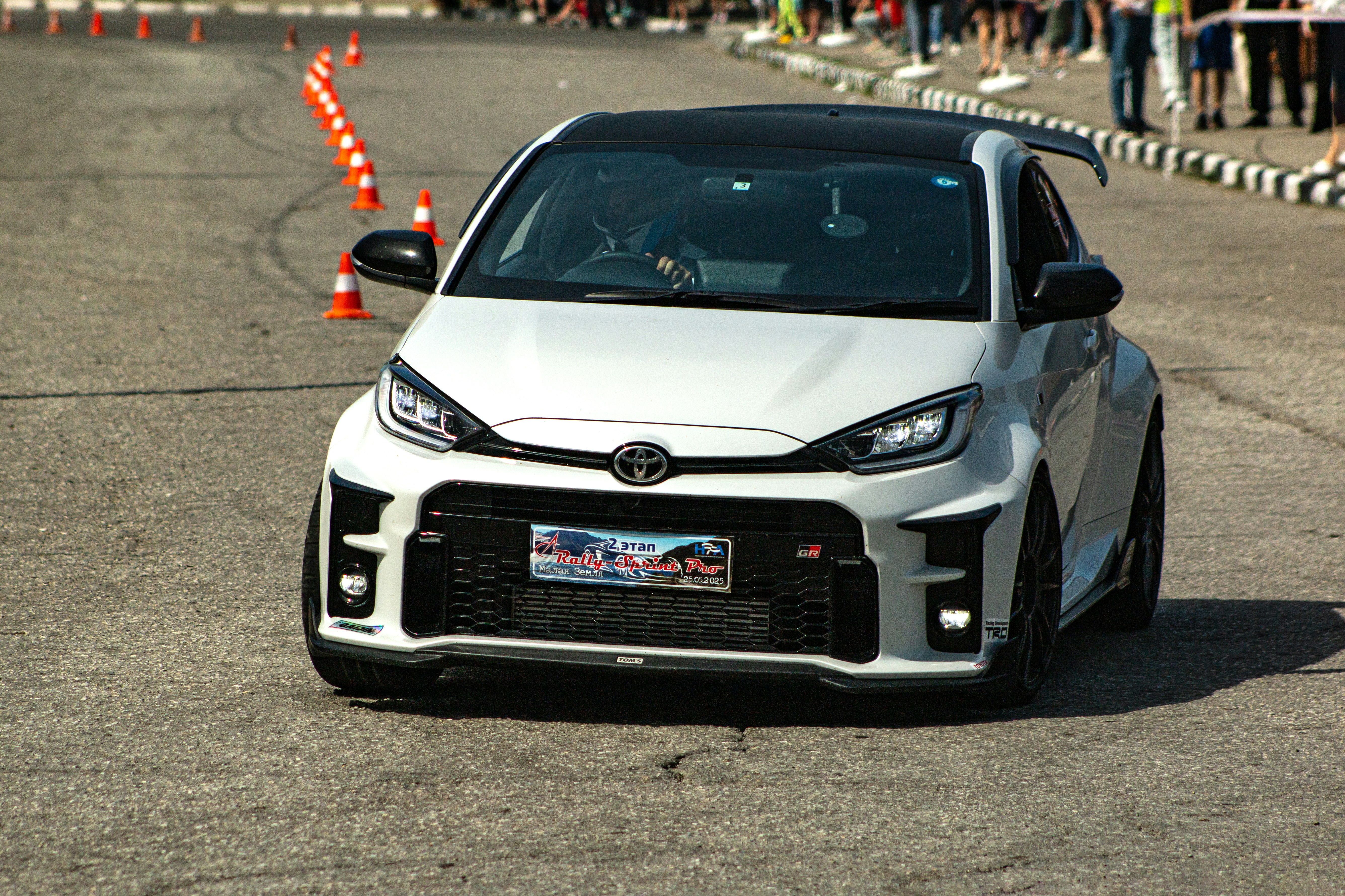 A white sports car races around a track.