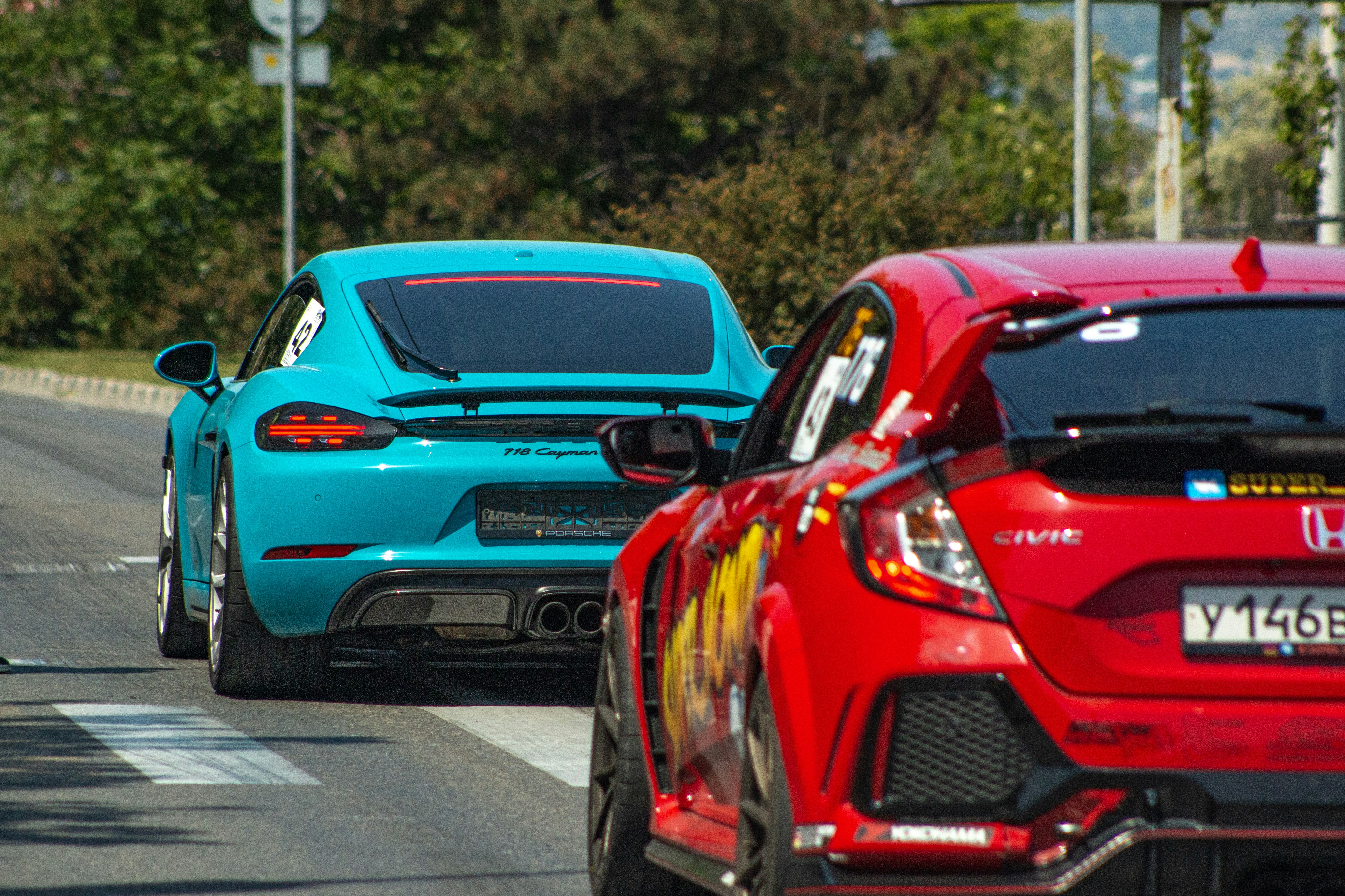Two colorful cars are seen on the road.