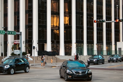 Cars drive on a road in front of a building.