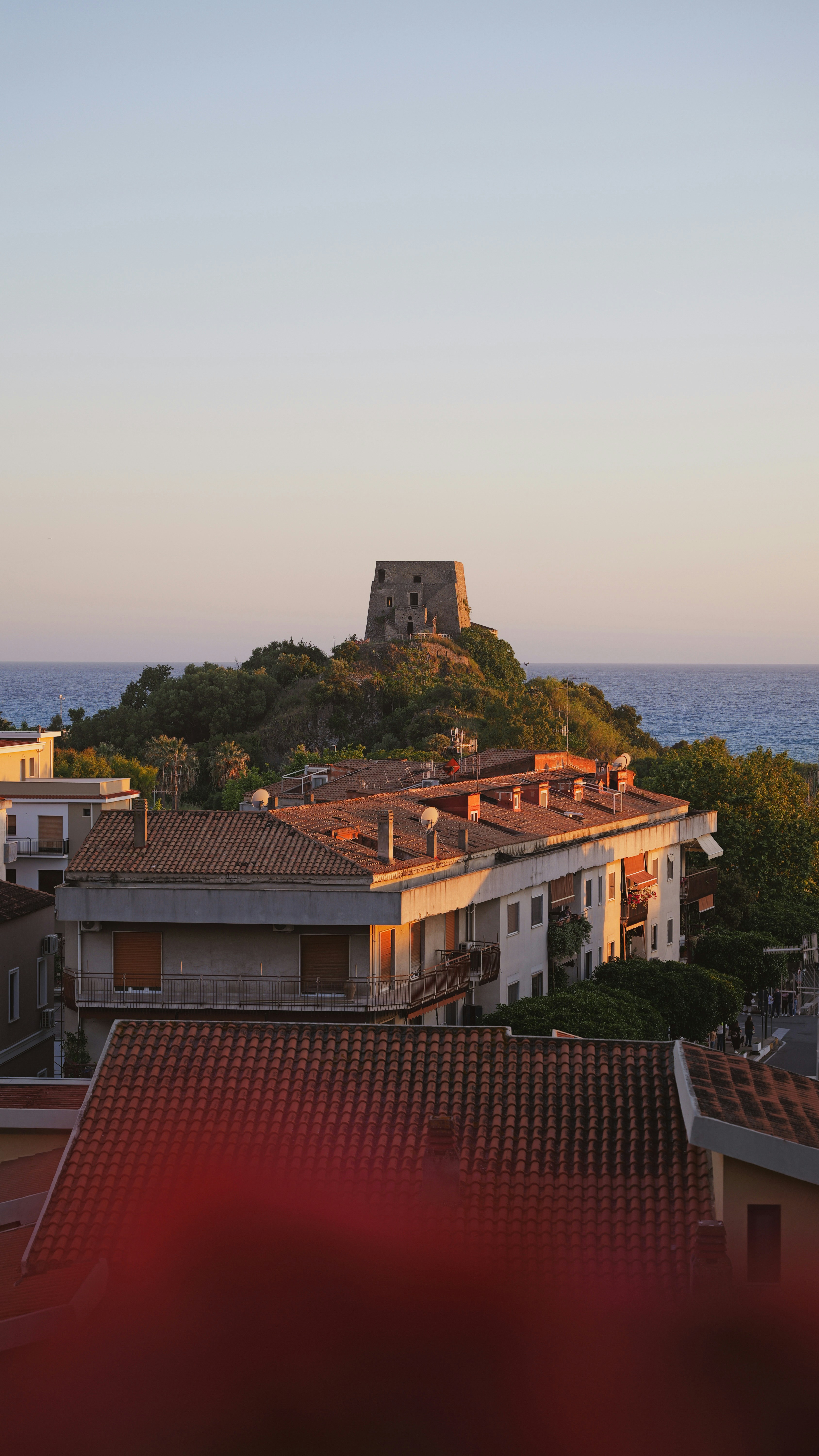 Buildings overlook the sea with a tower in the background