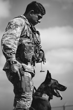 An airman stands with his military working dog.