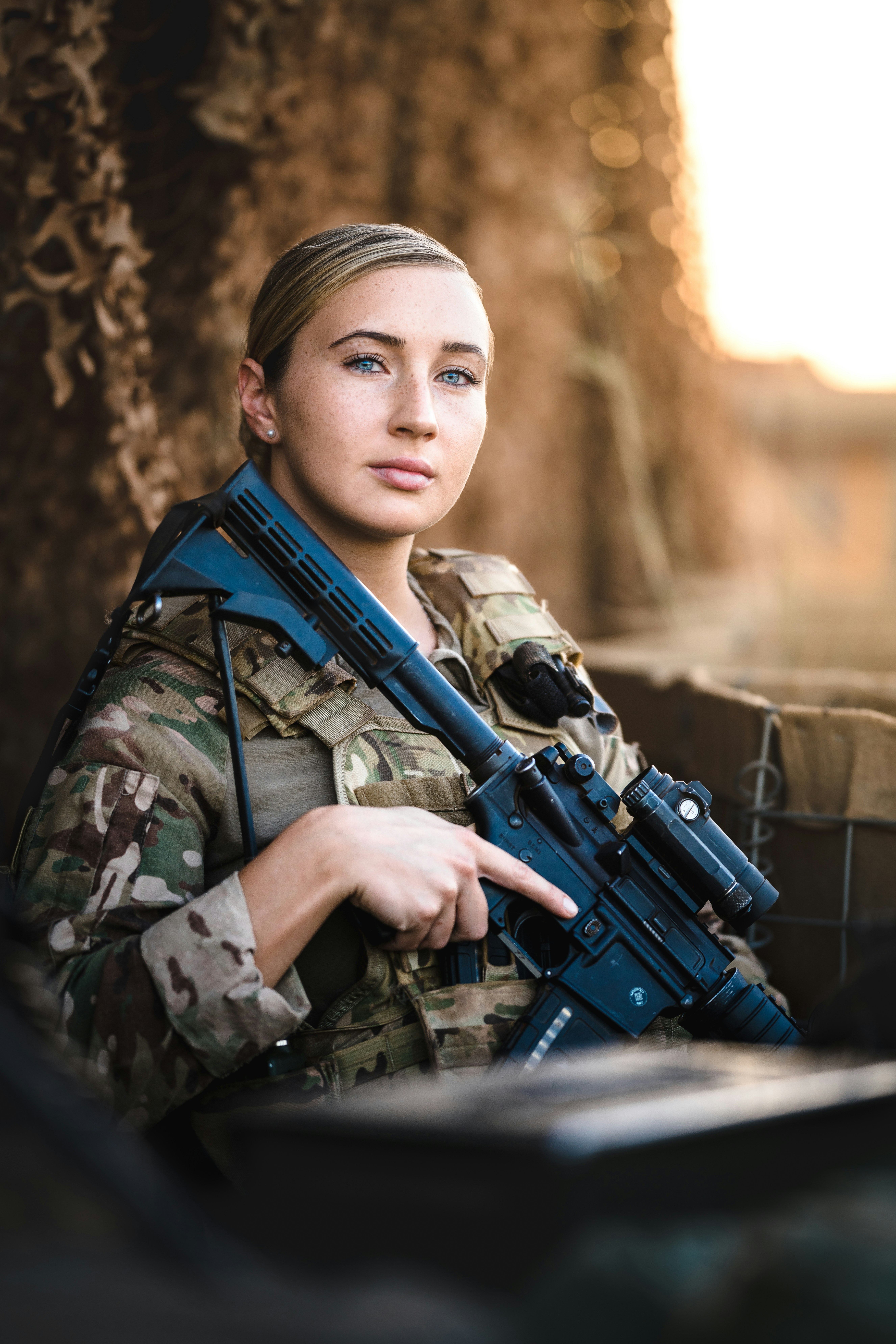 A female soldier holds a rifle.