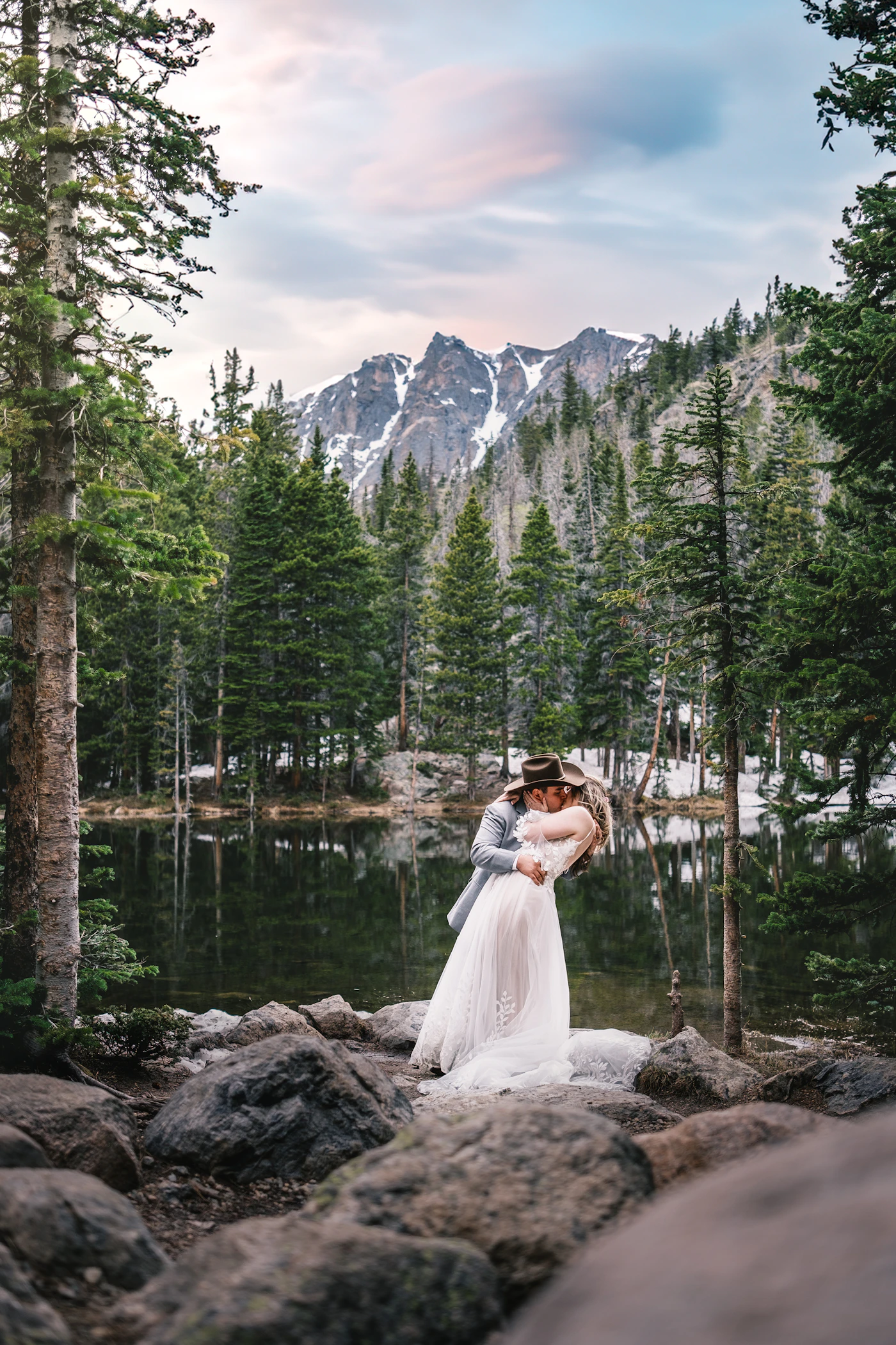 Couple in elopement ceremony attire in the Canadian Rockies near Canmore during their elopement photography session with the mountain peaks giving the dramatic Rockies backdrop