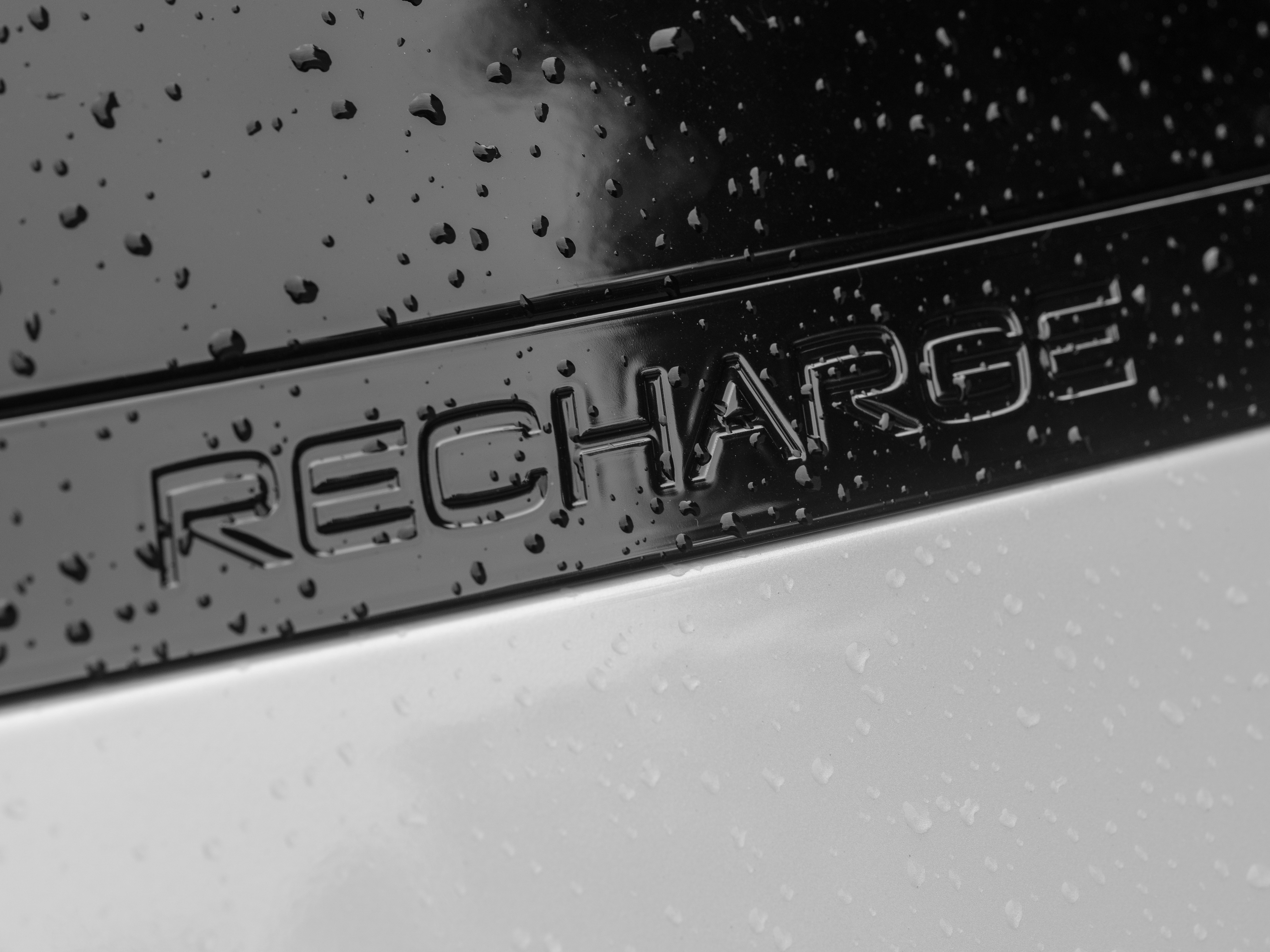 Coche híbrido enchufable conectado a un punto de recarga urbano con cable de carga visible