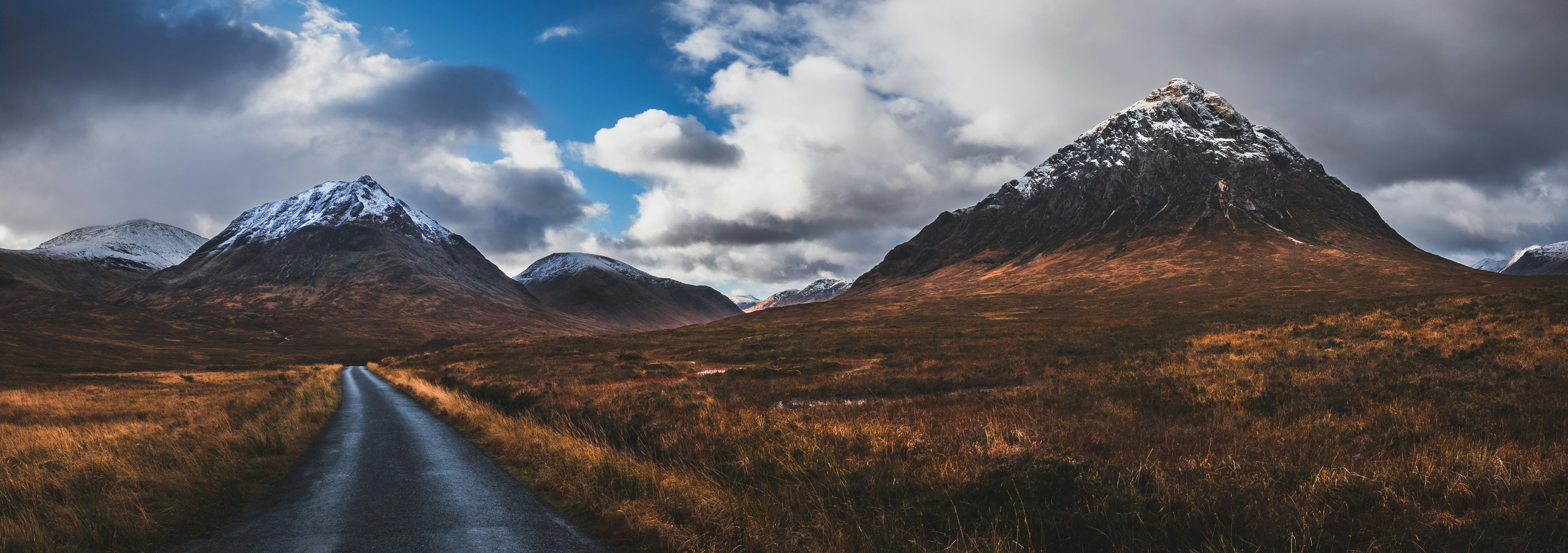 Road leads towards mountains in a scenic landscape.