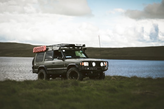 An off-road vehicle parks by the water.