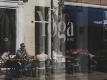 A yoga studio is reflected in the window.