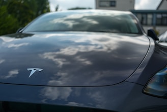 A tesla car reflecting the cloudy sky.