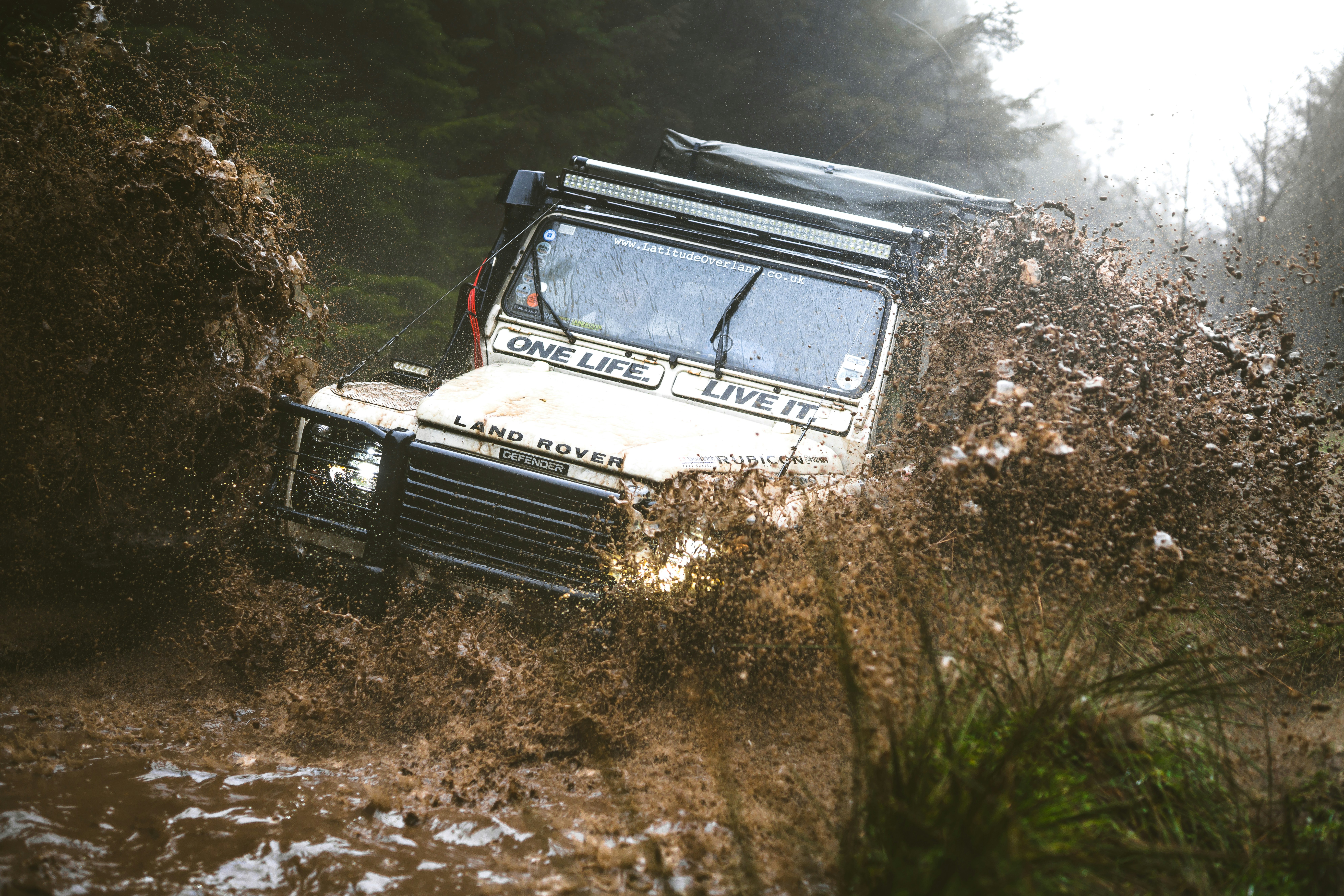 오프로드 차량이 진흙탕 물을 뚫고 튀어 나옵니다.