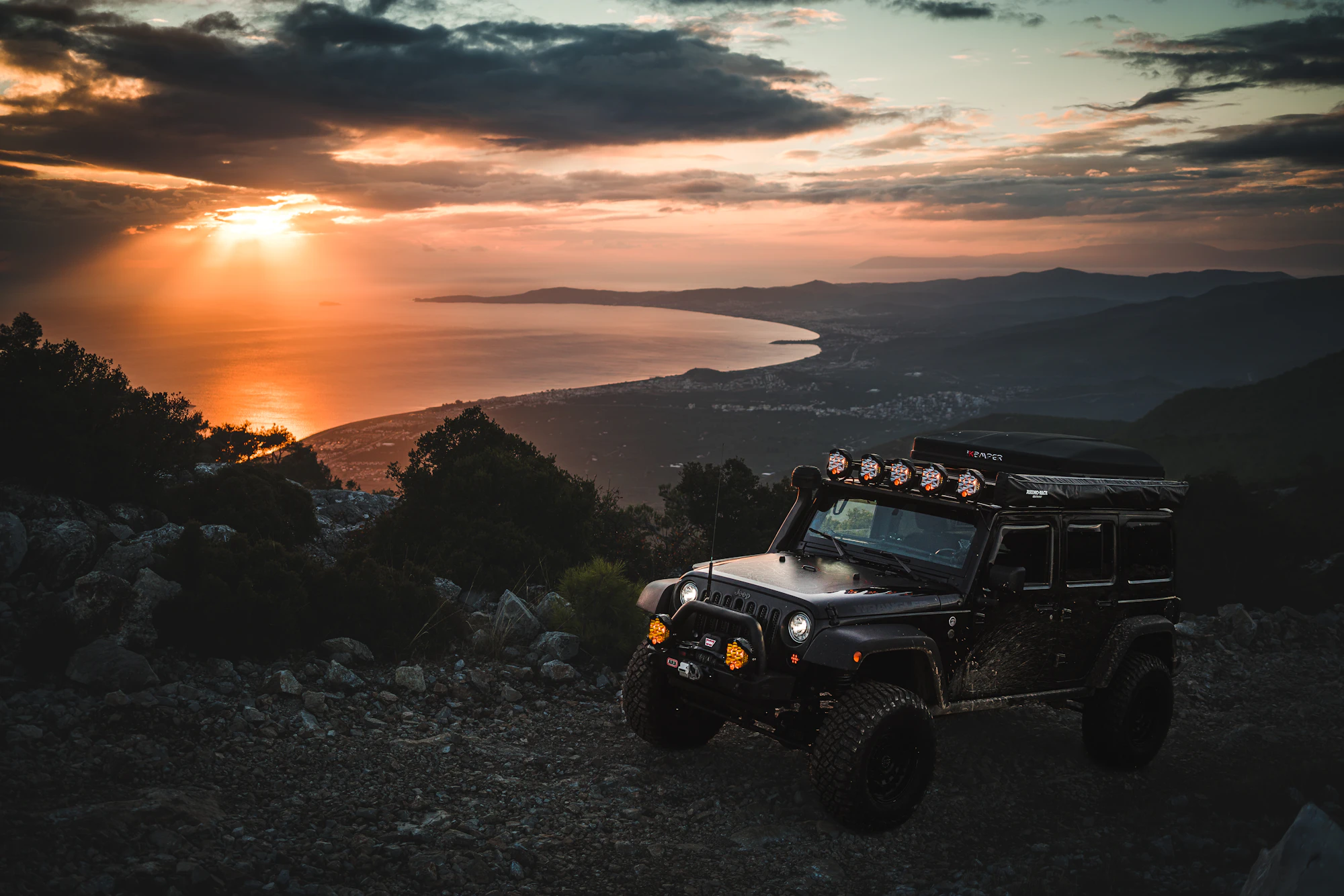 Off-road vehicle silhouetted at sunset