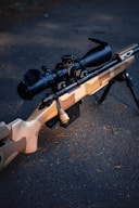 A camouflaged sniper rifle with scope.