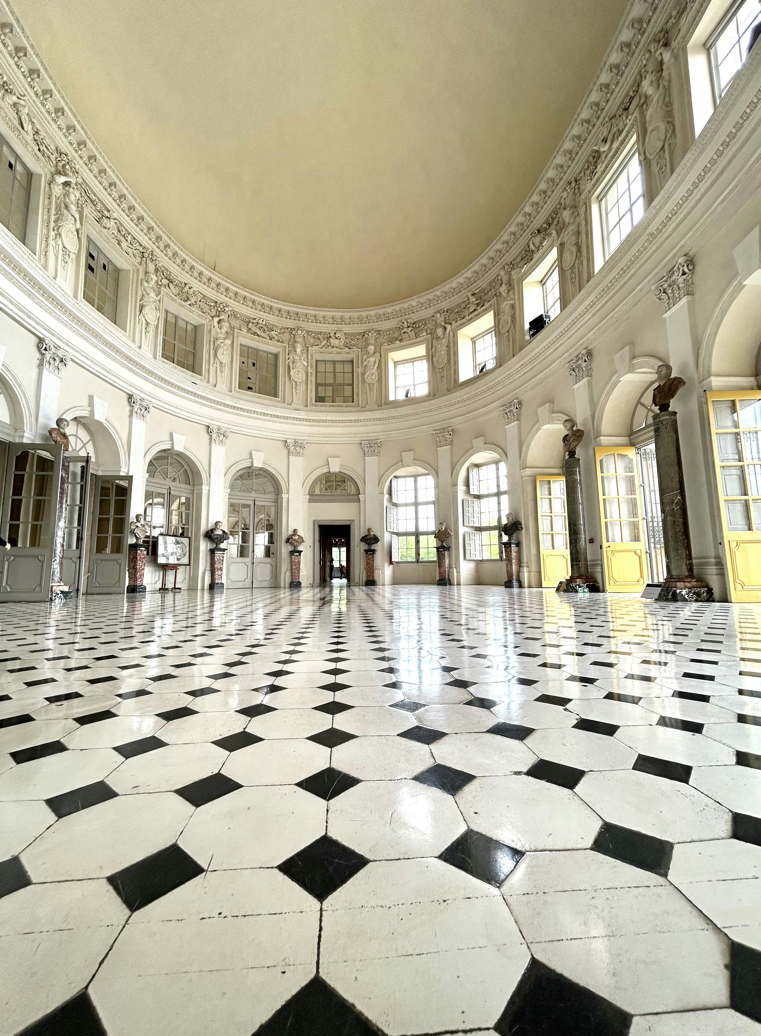 A grand, ornate room with a checkered floor.