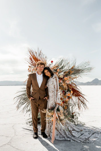 A newlywed couple poses on a sunny day.