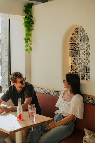 Couple chatting in a stylish, brightly lit cafe.