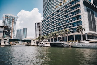 Boats float on water with tall buildings in miami.