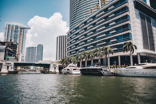 Boats float on water with tall buildings in miami.