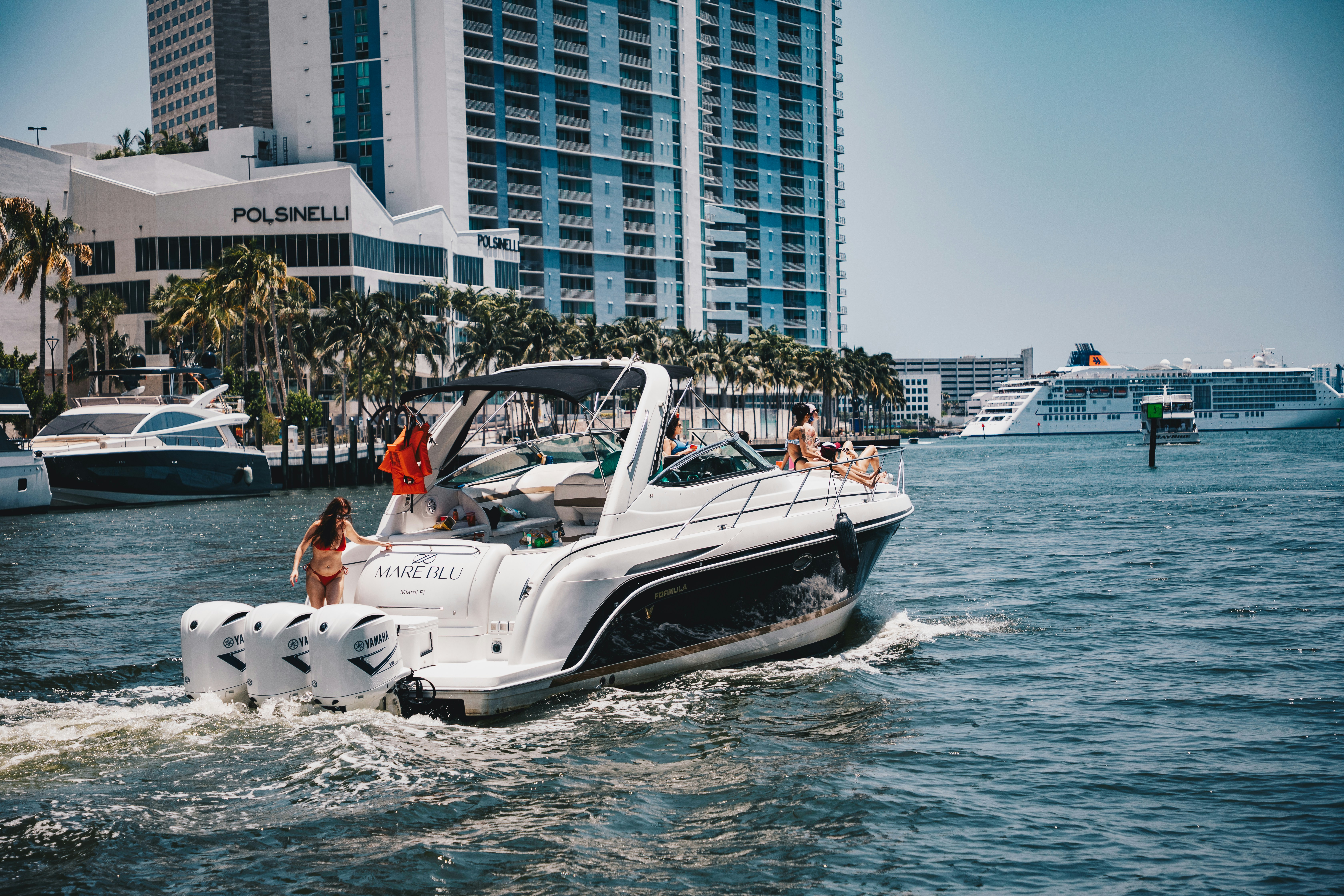 A motorboat cruises the water near city buildings.
