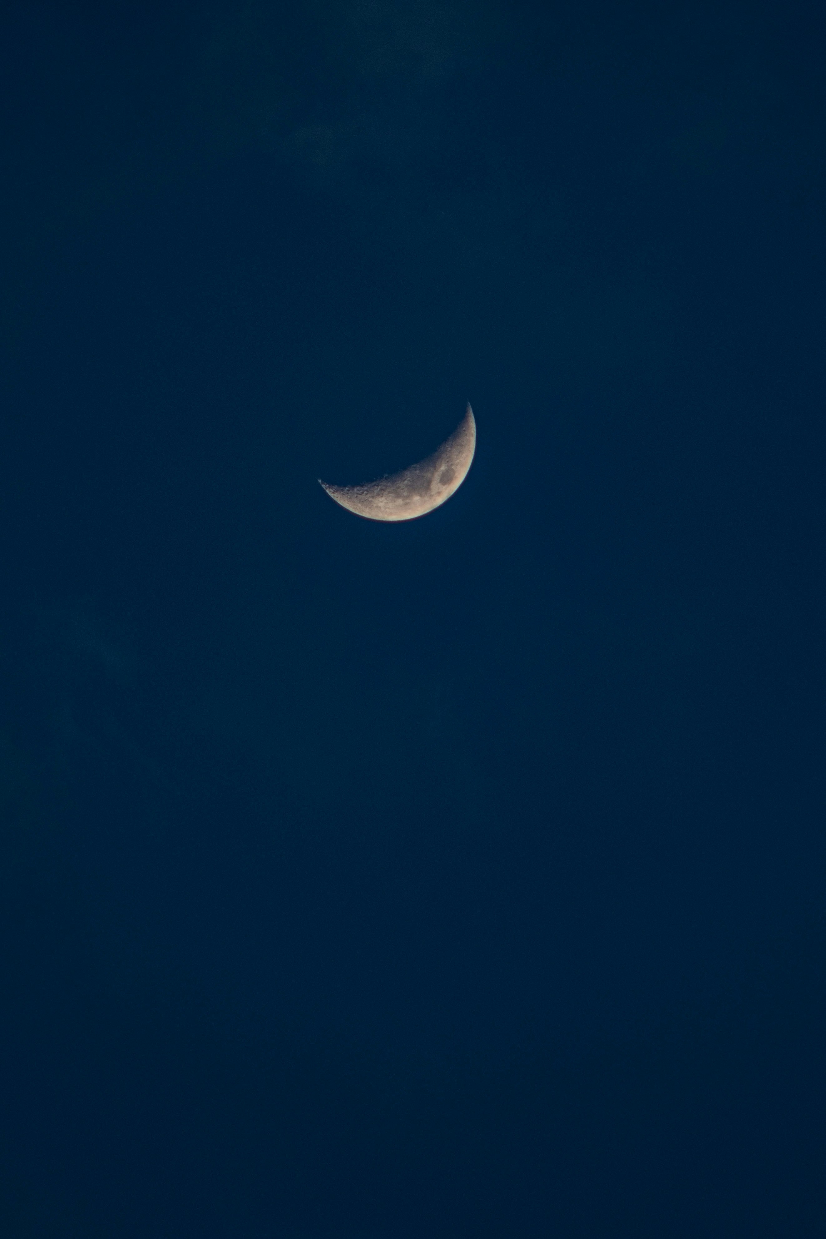 Crescent moon shines brightly in the night sky.
