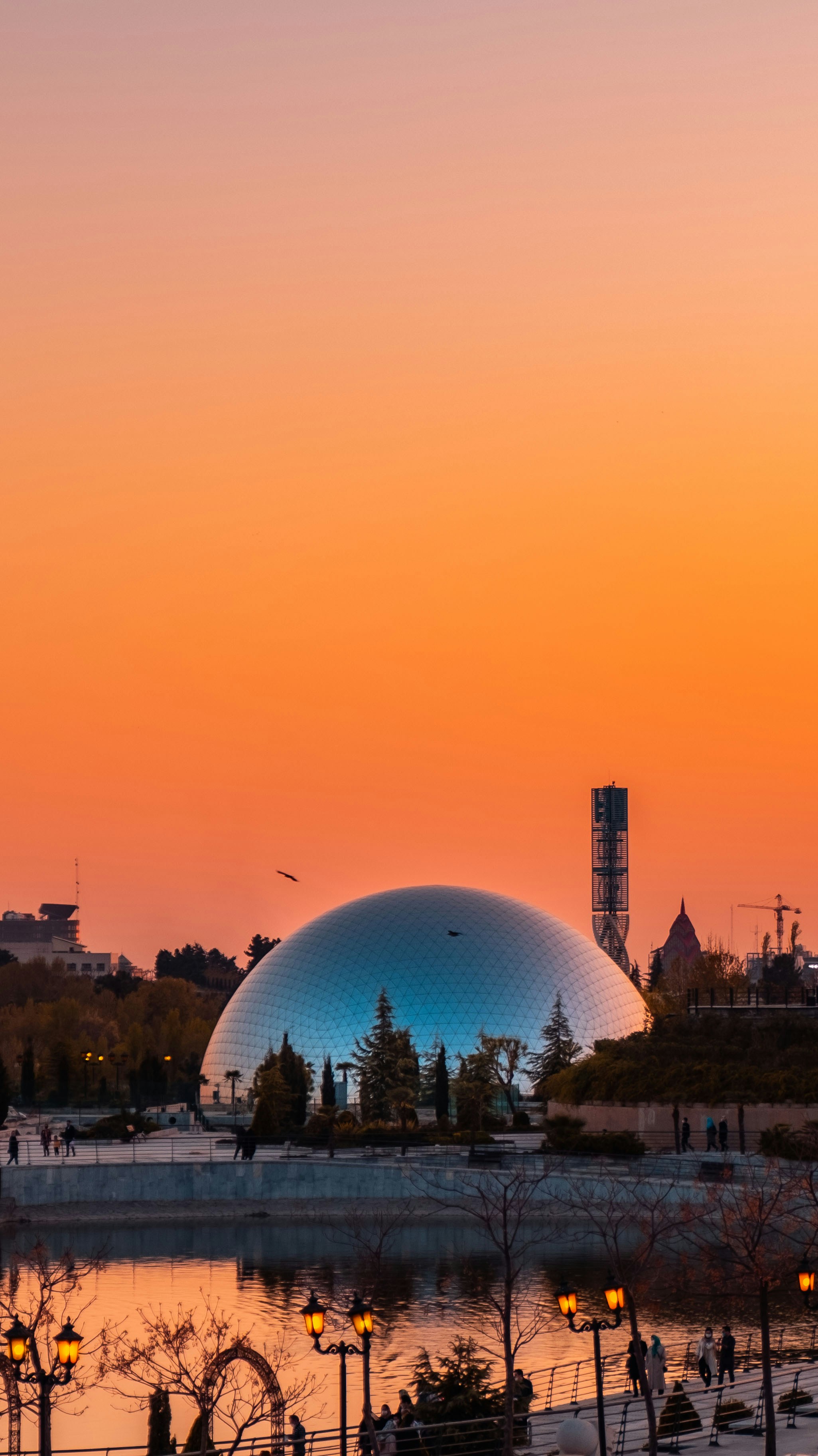 A dome building reflects the colorful sunset.