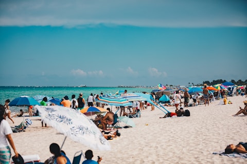 People relax and enjoy the beach on a sunny day.