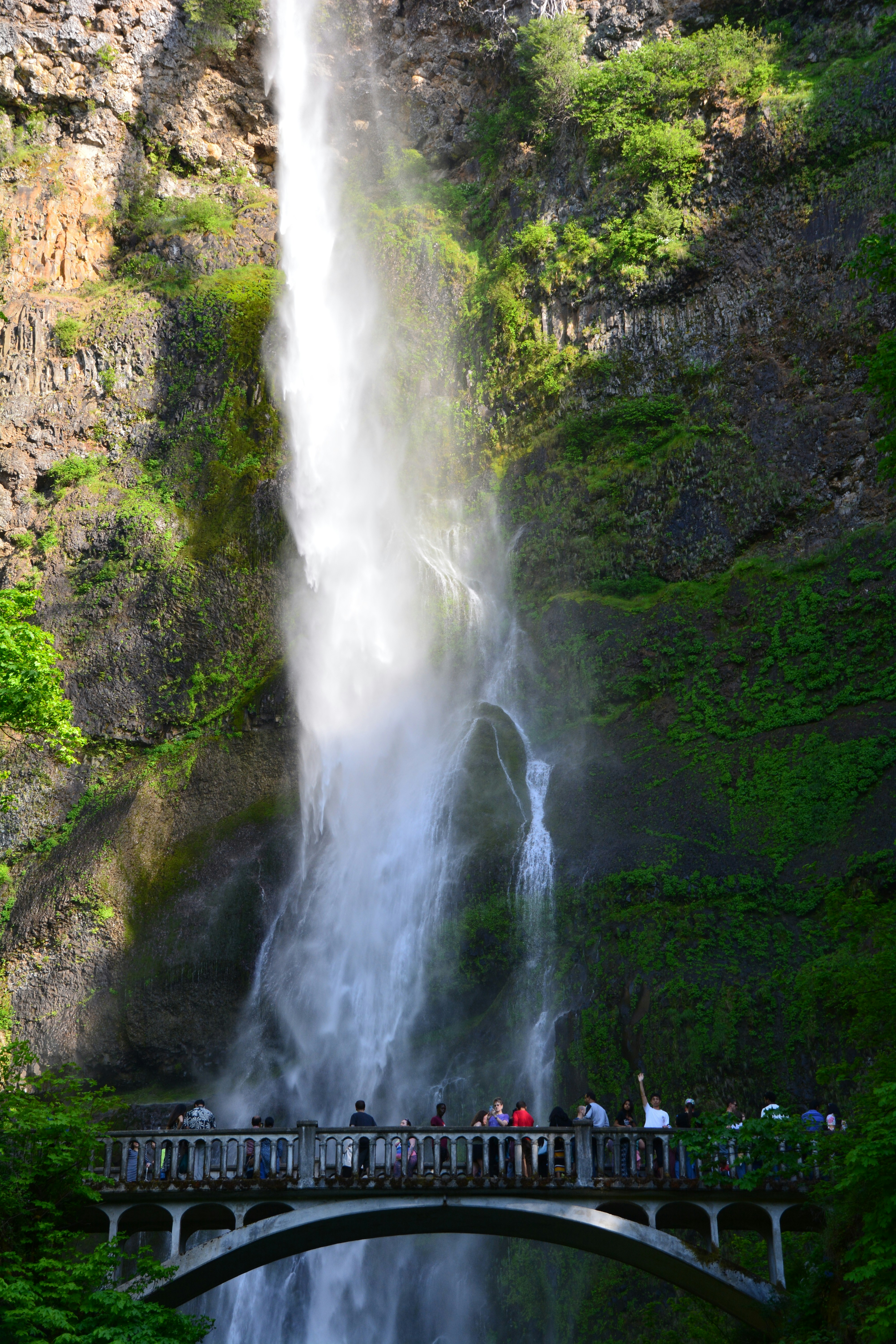 A stunning waterfall cascades over a bridge.