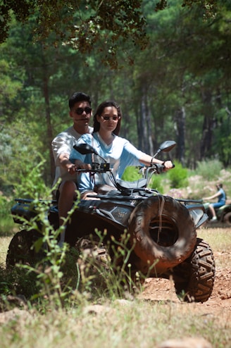 Couple enjoys an atv ride in the forest.