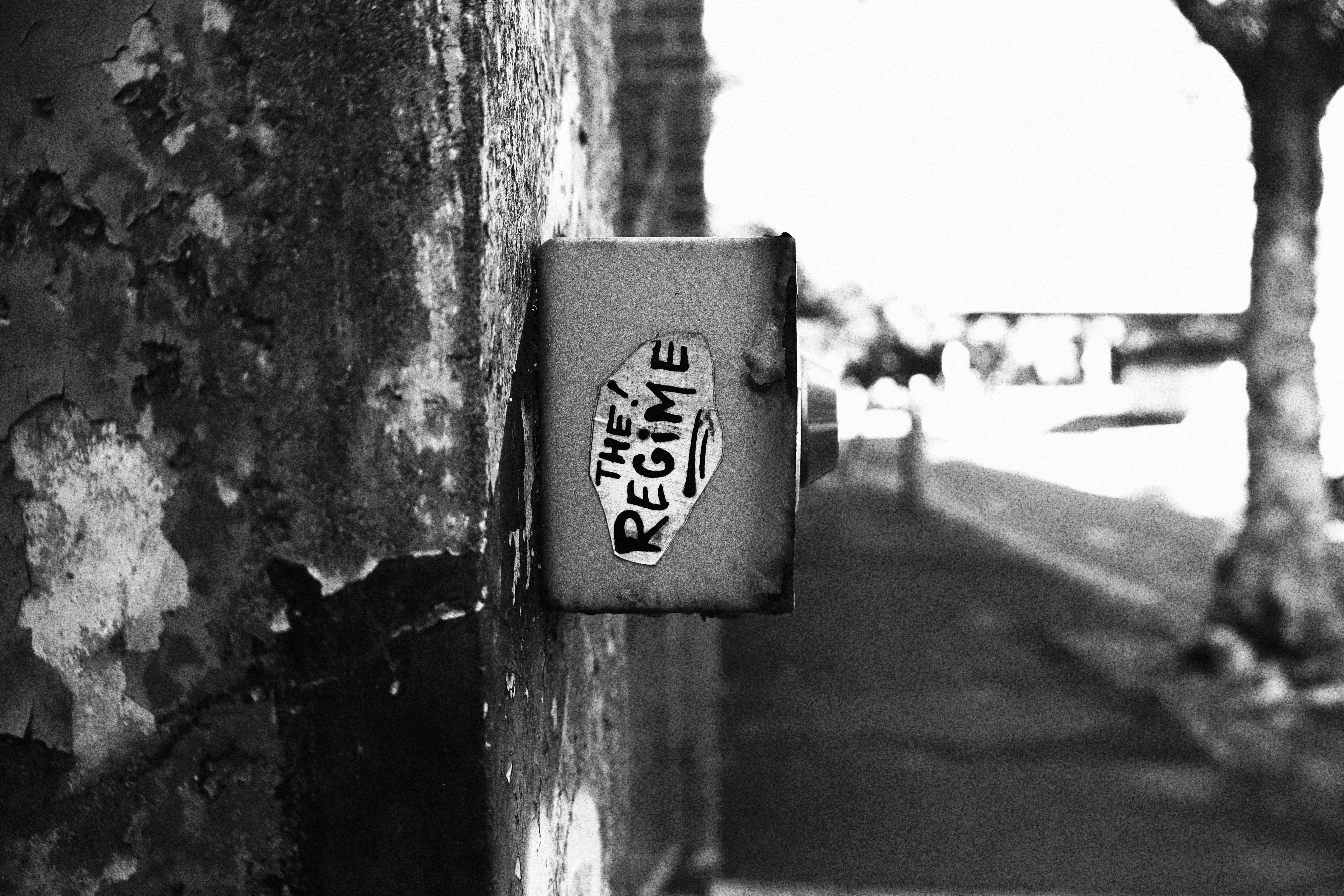 A box displays "the regime" against a gritty wall.