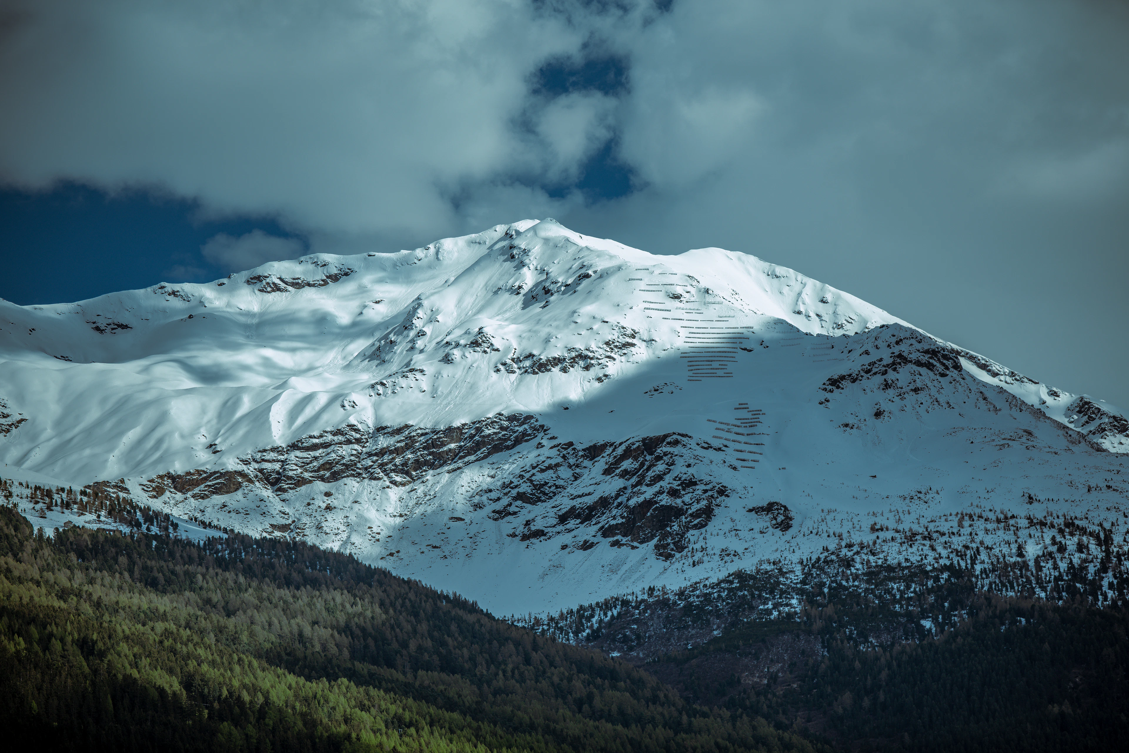 Snowy peaks above Bormio under a cloudy sky