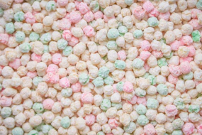 Colorful sprinkles or candies fill the image.