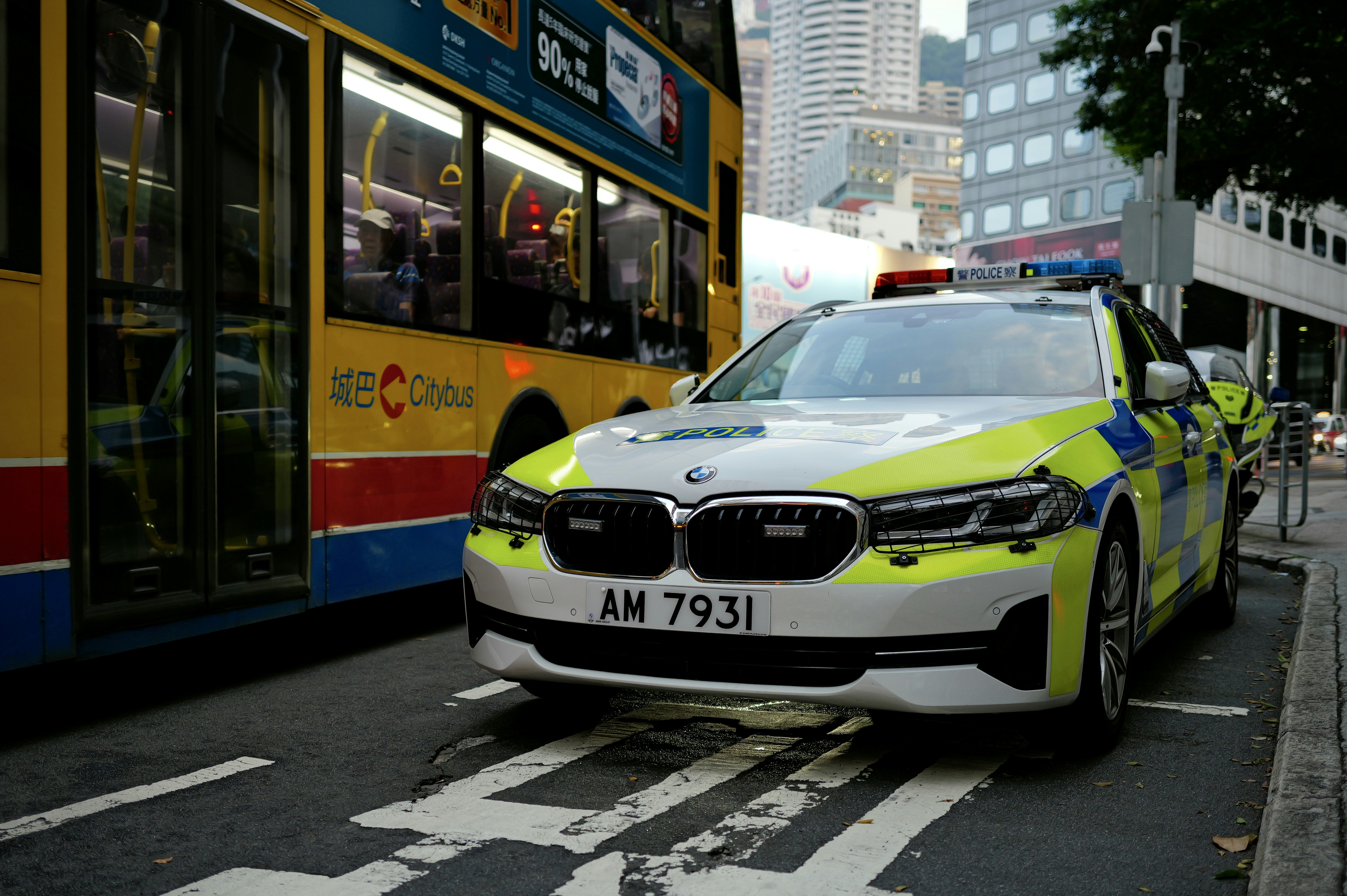 Police car parked next to a bus on a city street.