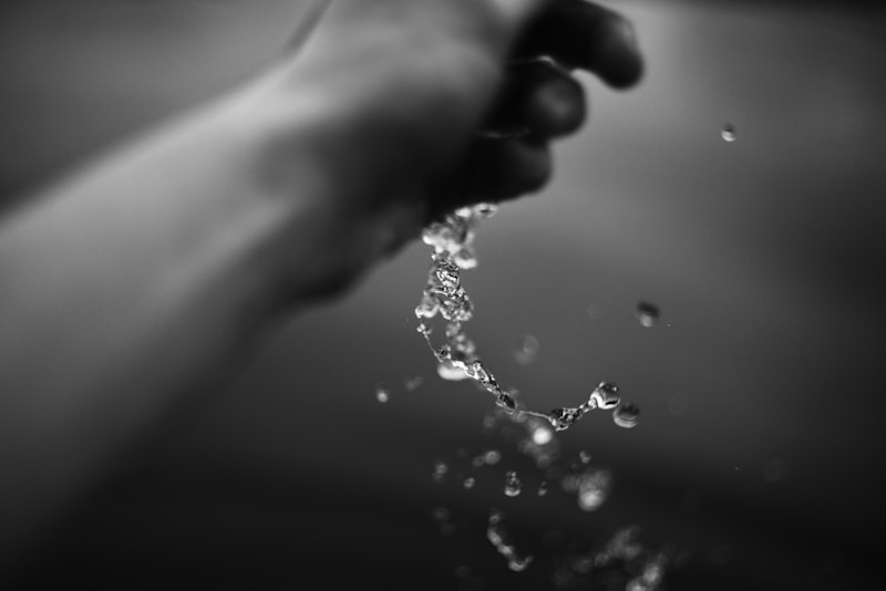 Hand pouring water, black and white