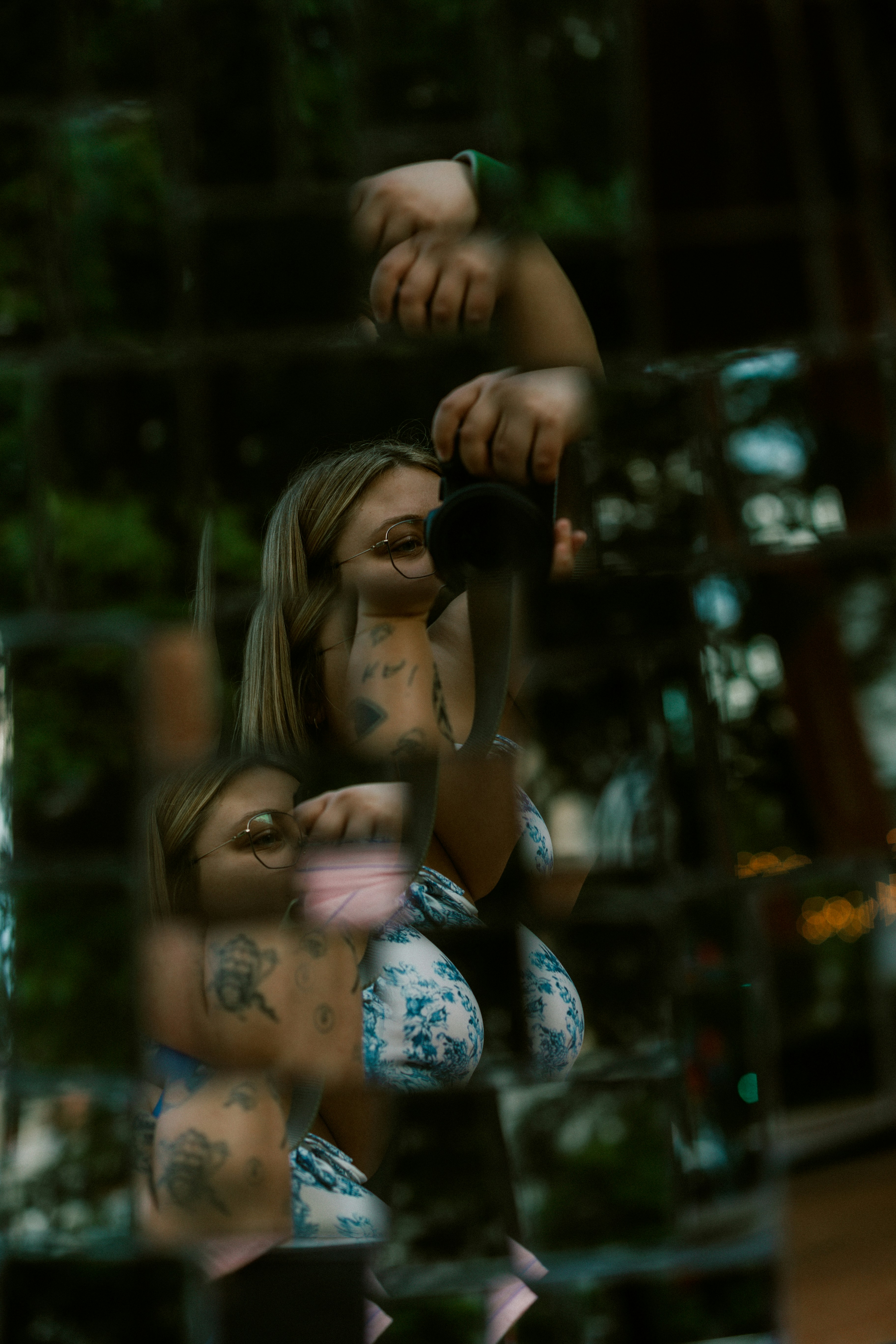A woman photographs herself in a shattered mirror