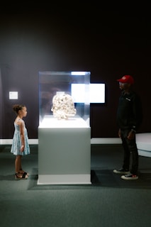 A girl and man admire art in a museum.