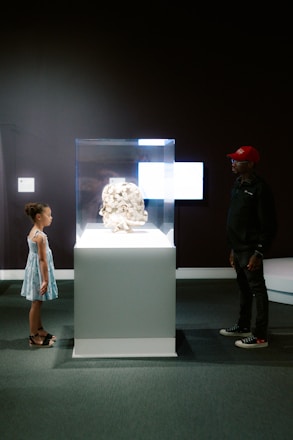 A girl and man admire art in a museum.