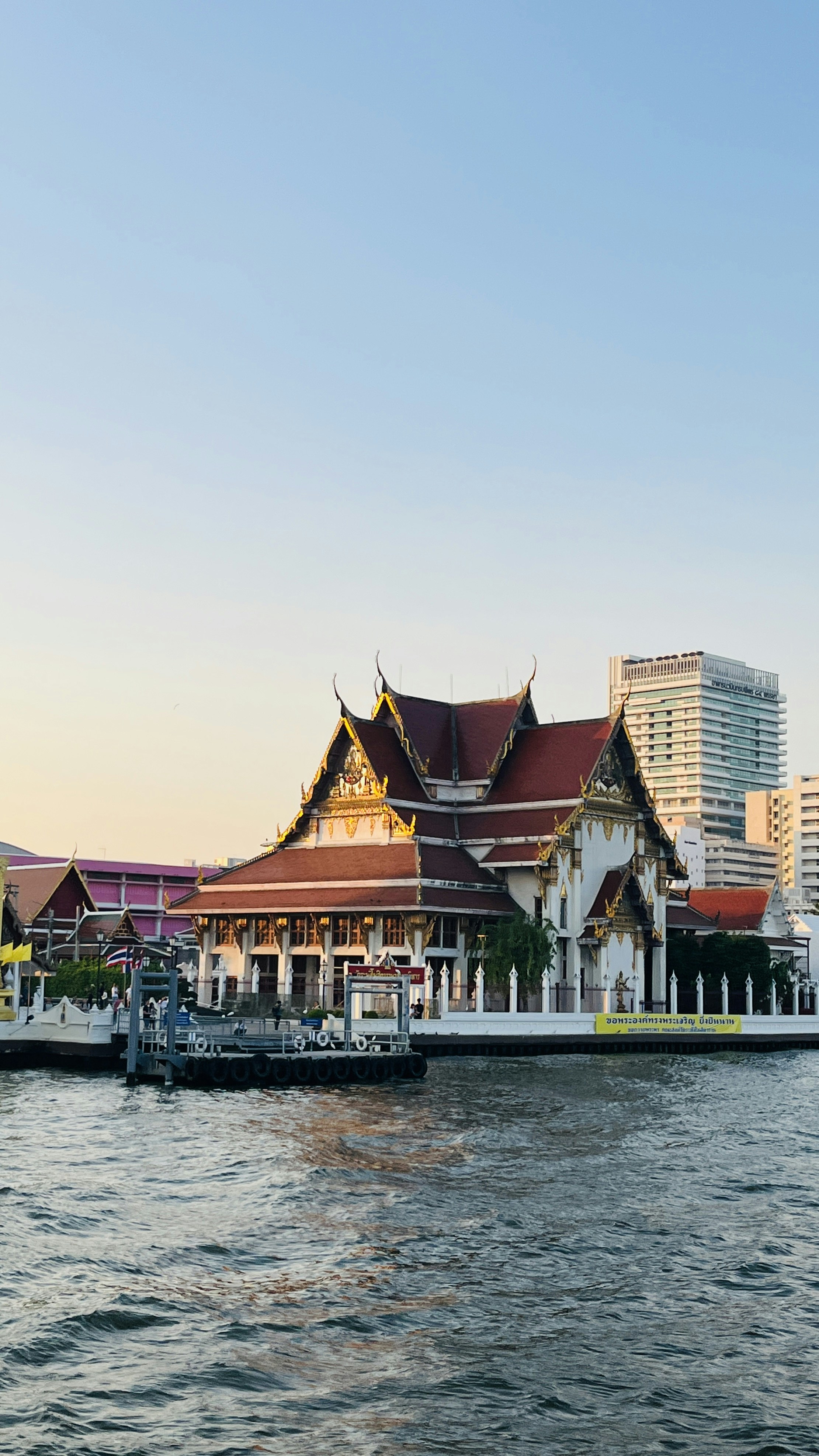 A thai temple by the river in the evening.