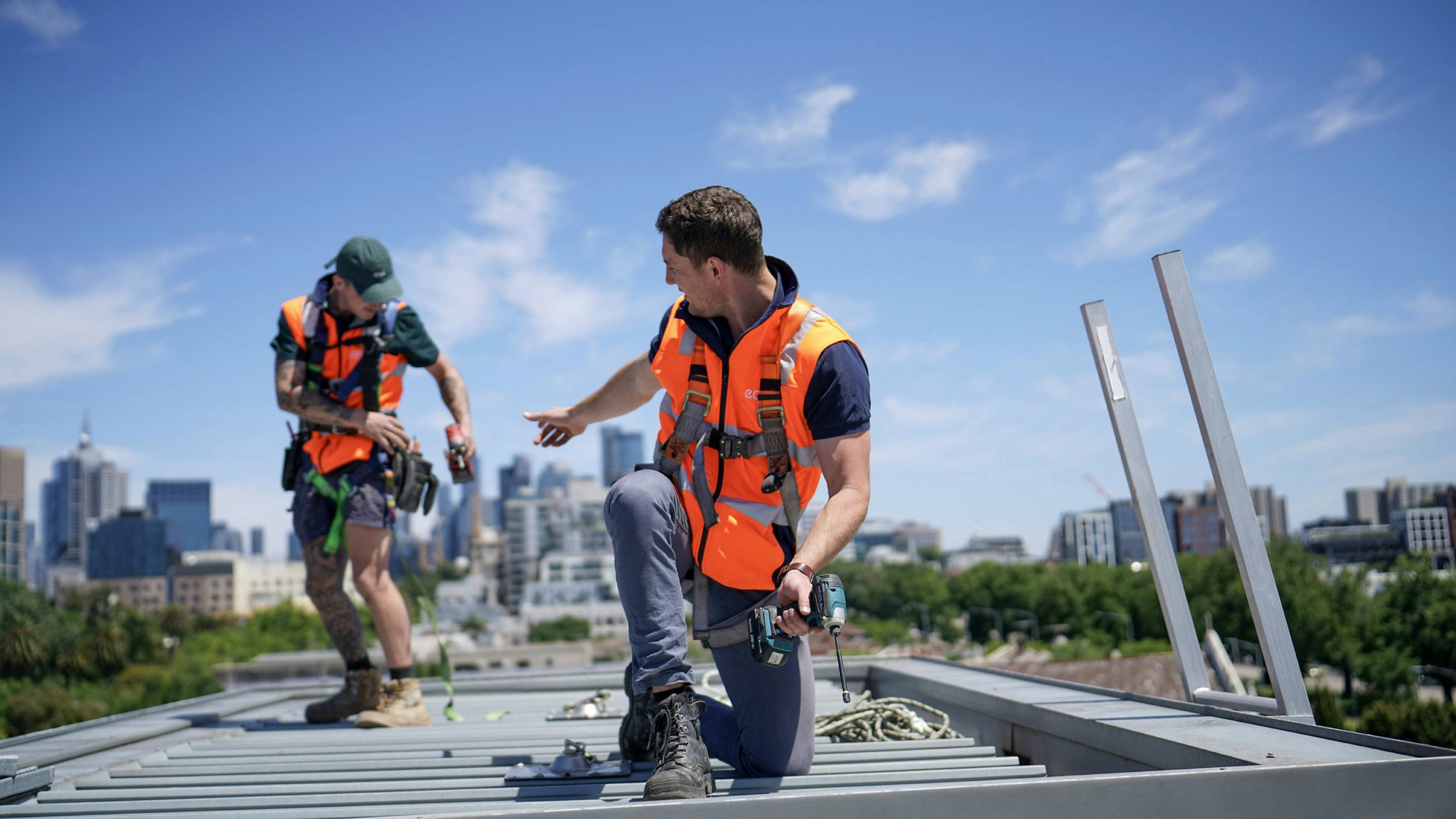 professional, friendly roofing crew at work wearing safety harnesses - Free roof estimate