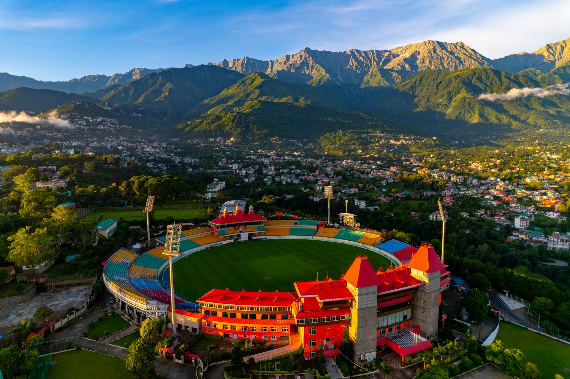 A cricket stadium with mountains in the background.