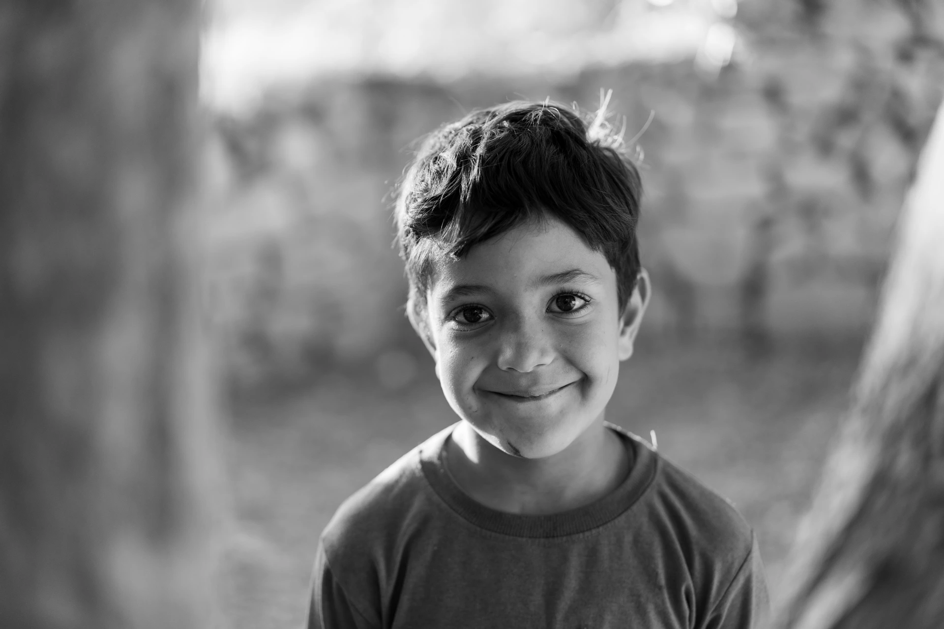 A smiling child looks directly at the camera