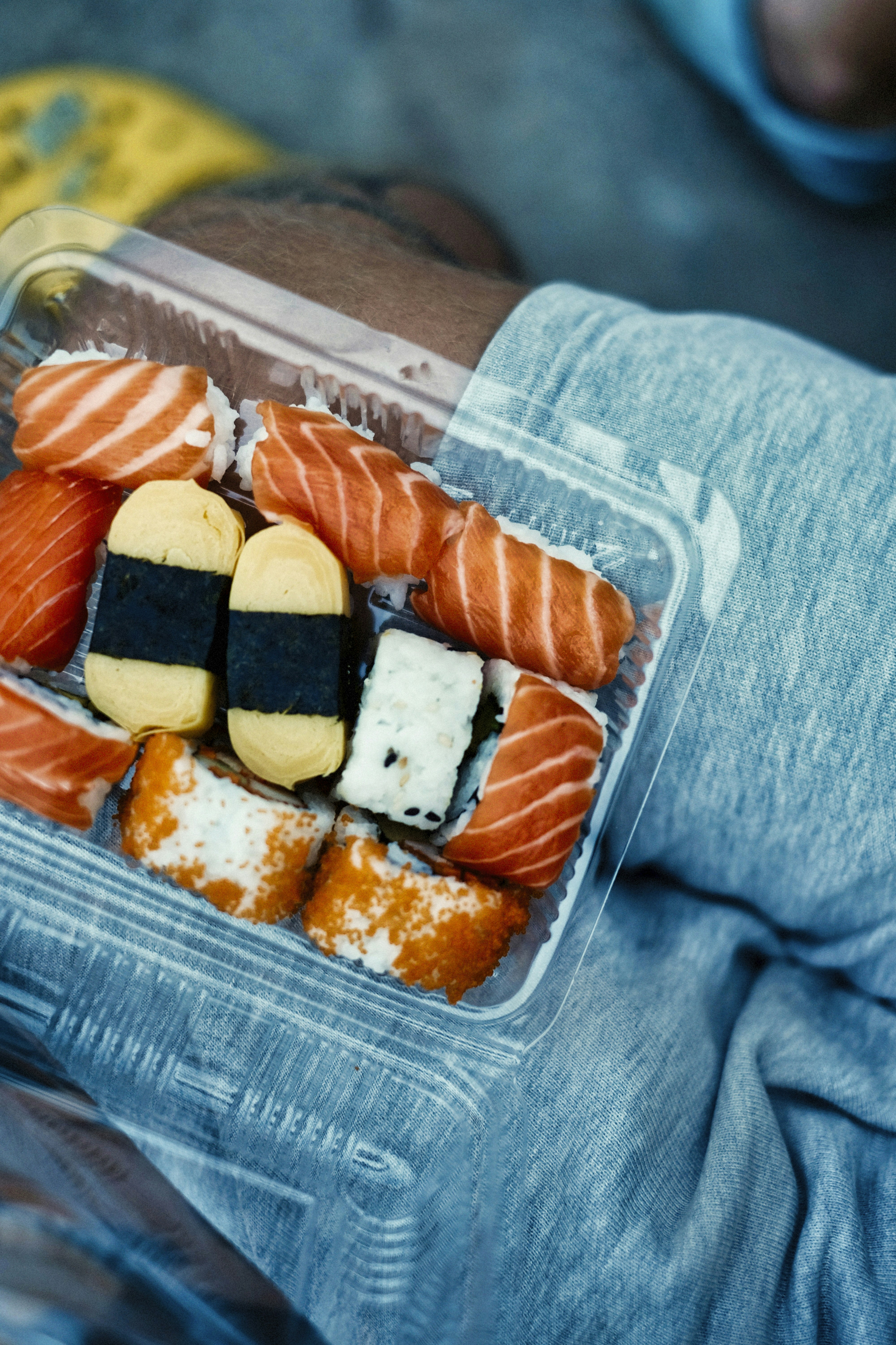 Sushi in a clear container, ready to eat.