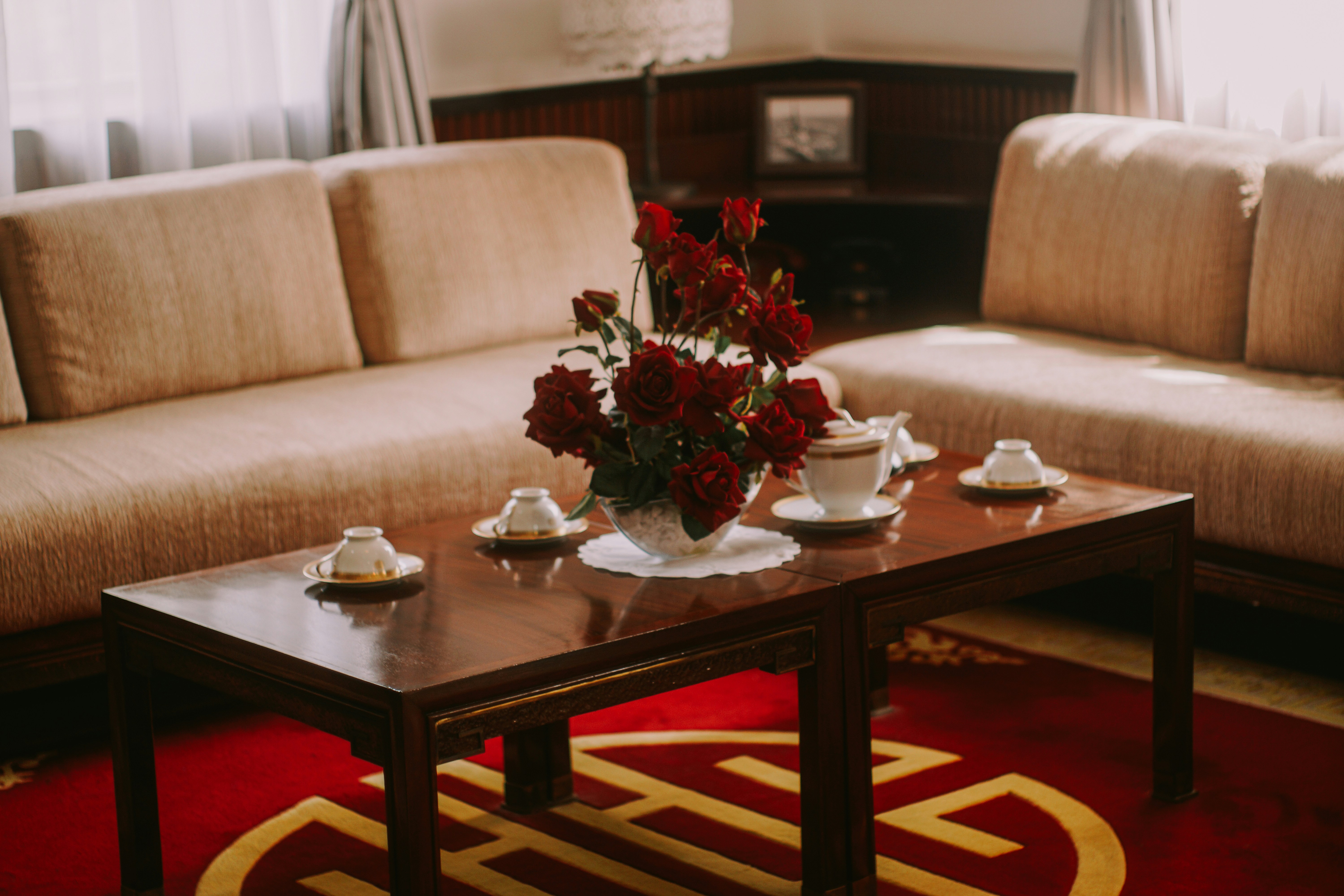 A living room with flowers and coffee cups.