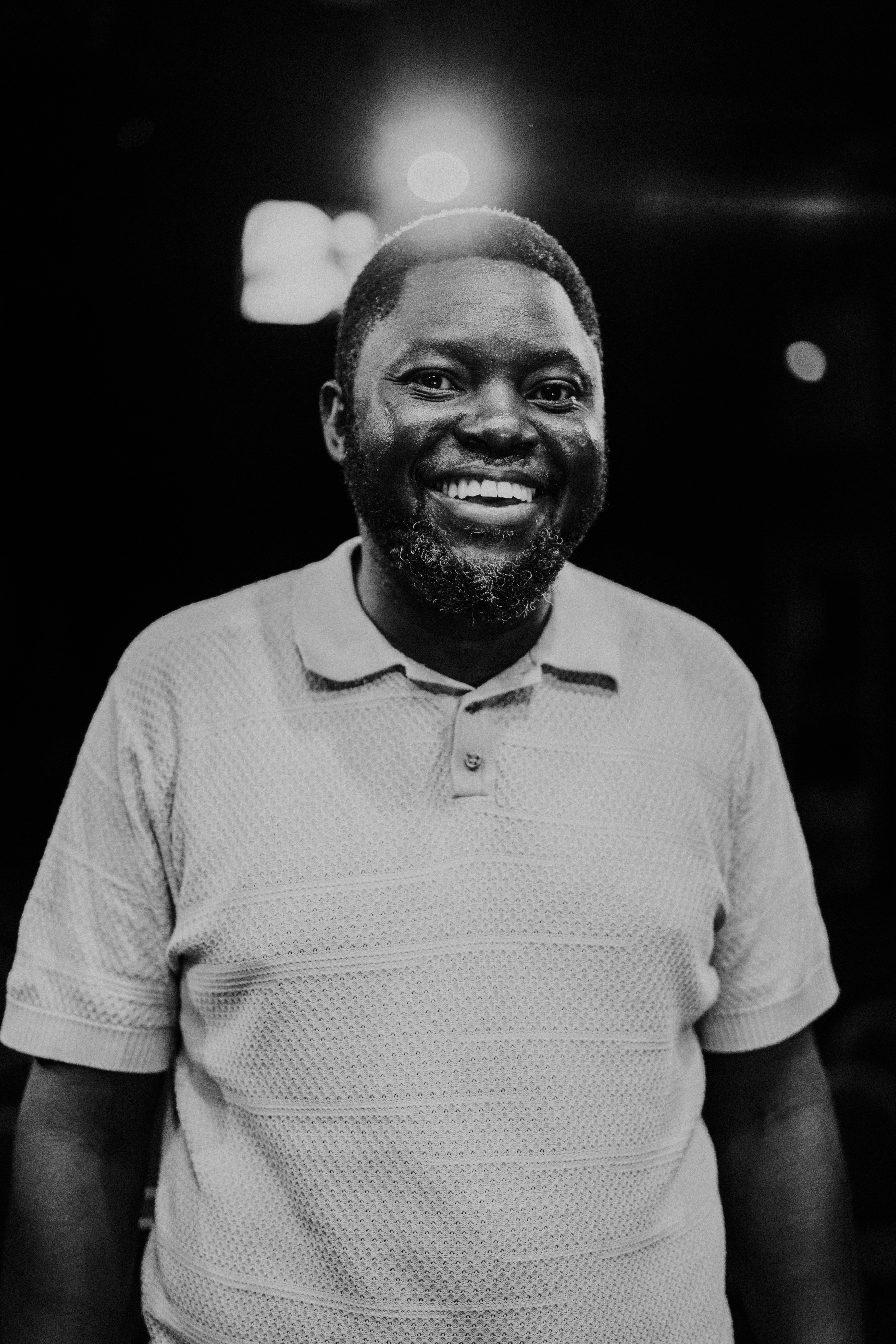 Smiling man in black and white portrait.