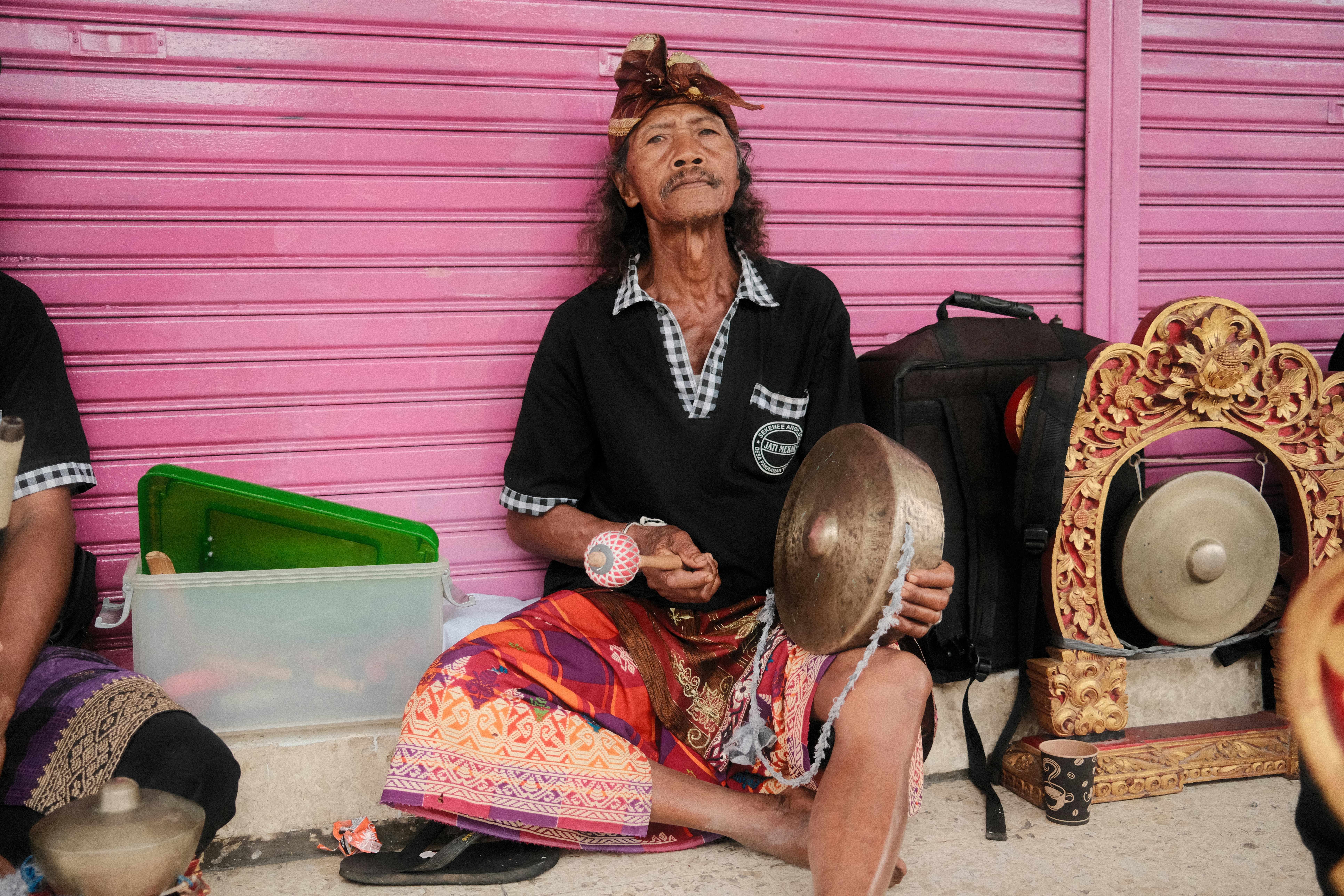 A musician plays traditional instruments outside.