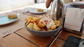 Patatas bravas served in a bowl on a table.