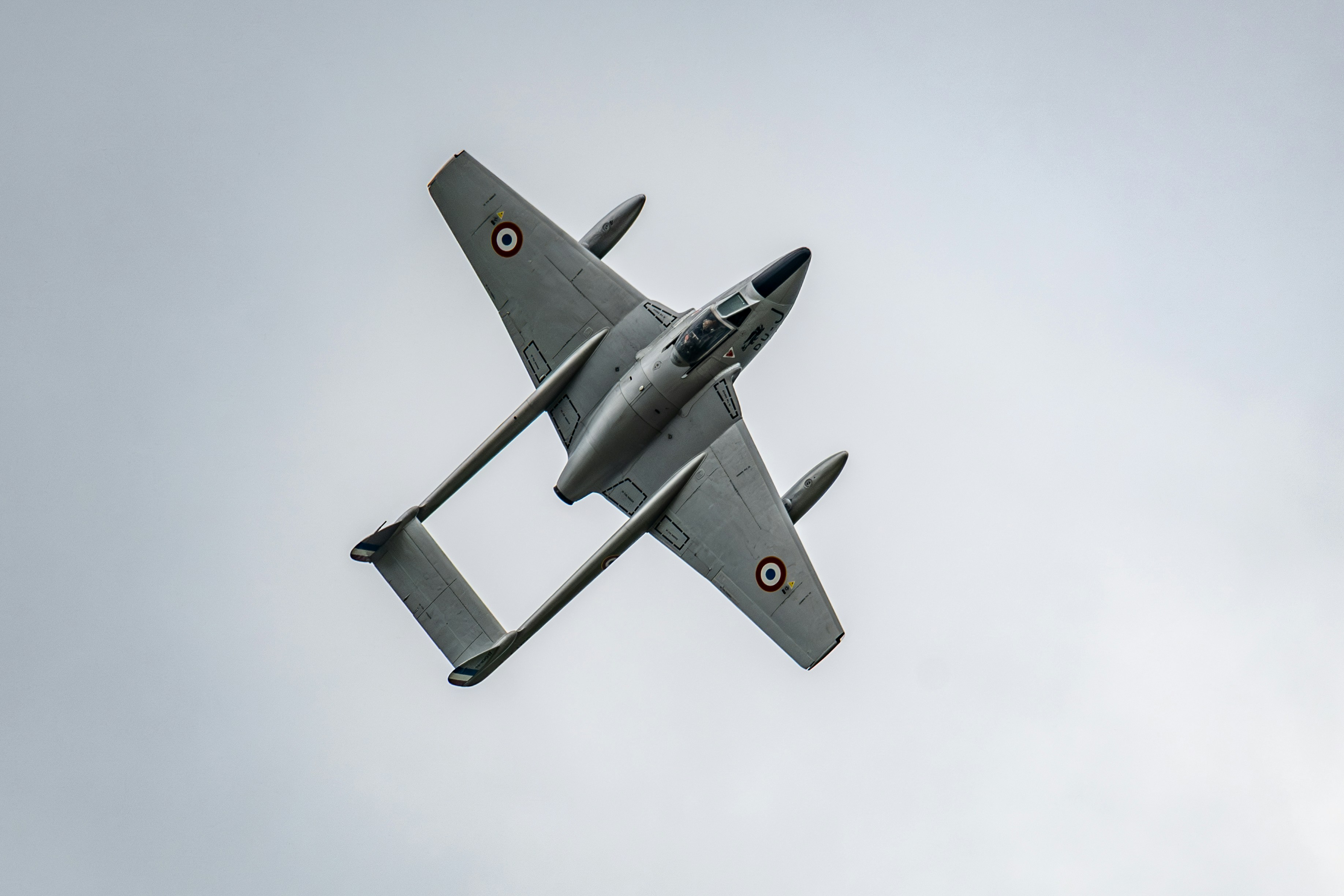 Un avion de chasse à réaction d’époque s’élève dans le ciel.