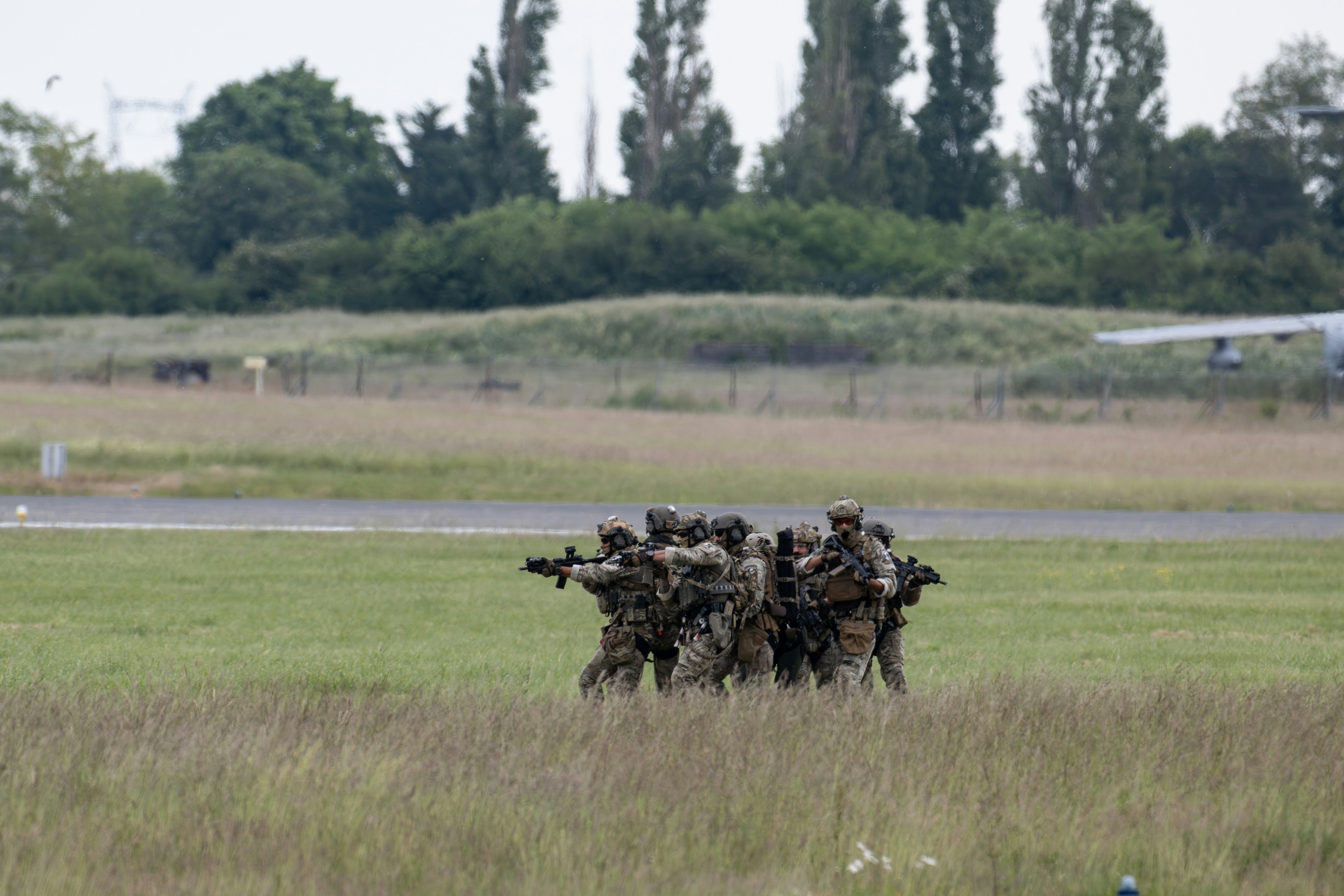 Des soldats en formation pointent leurs armes.